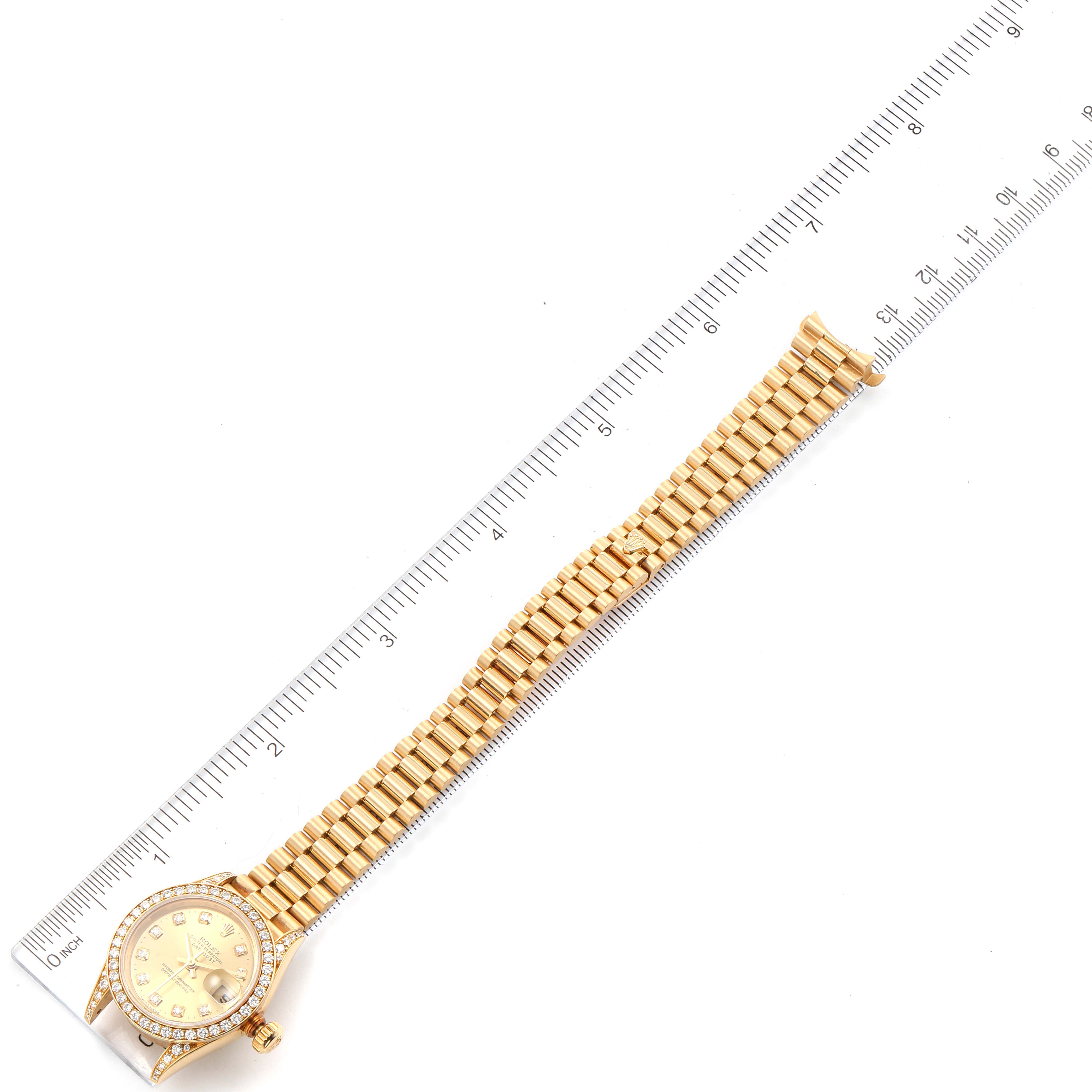 This image shows a Rolex President 79158 Women
s Yellow Gold Champagne Dial 79158 Women
s Yellow Gold Champagne Dial model watch with a gold bracelet, measured alongside a ruler.