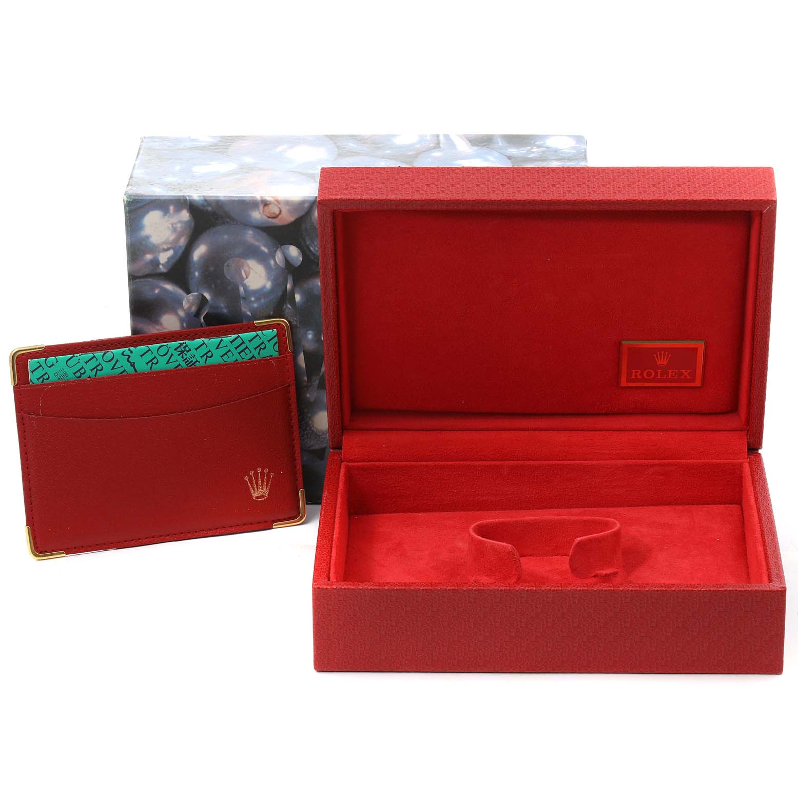 The image shows a red Rolex President 79158 Women
s Yellow Gold Champagne Dial 79158 Women
s Yellow Gold Champagne Dial model watch box and a red cardholder from an eye-level angle.