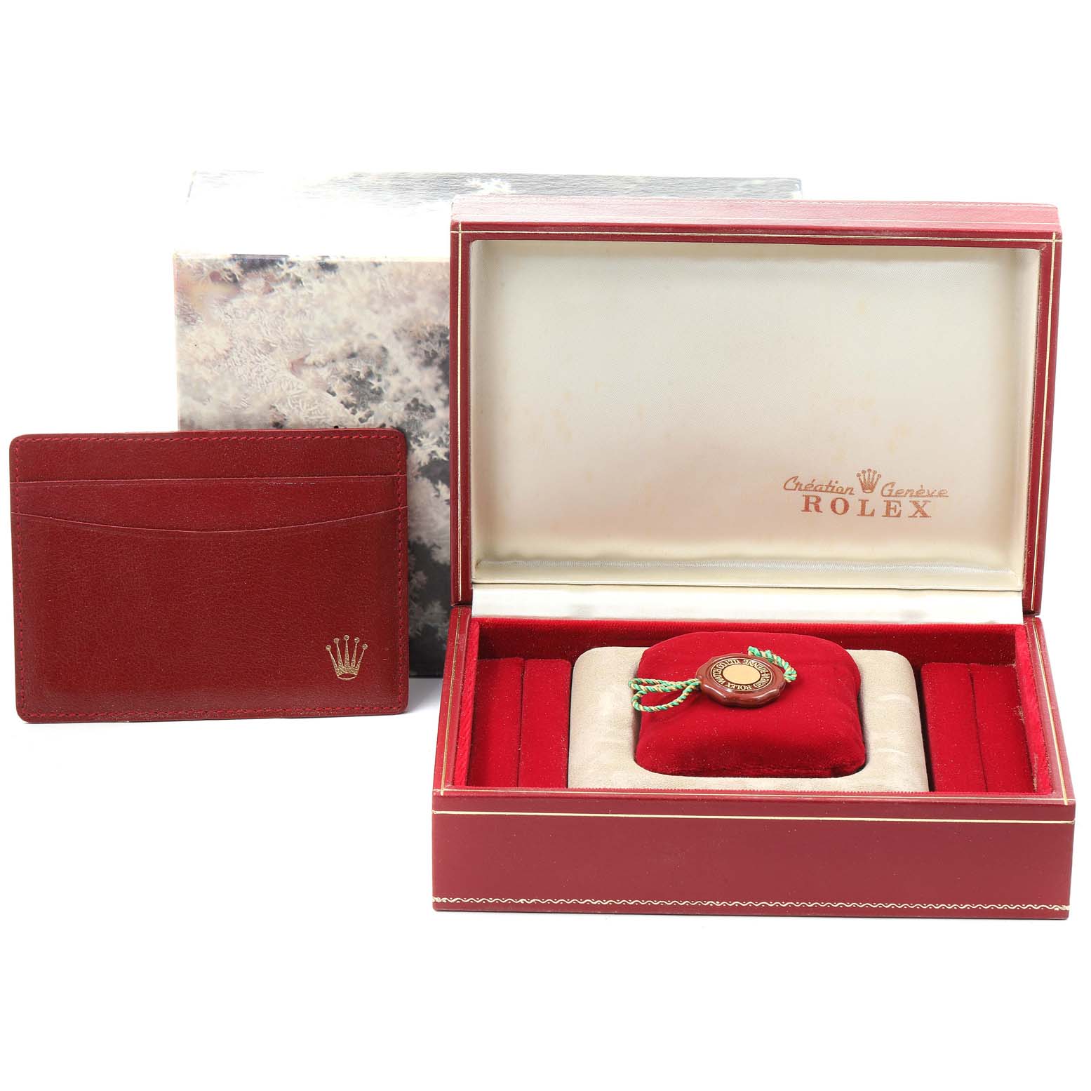 This image shows a Rolex President 69038 Women's Yellow Gold Champagne Dial 69038 Women's Yellow Gold Champagne Dial model watch box and accessories, including a red cardholder and a red velvet cushion.