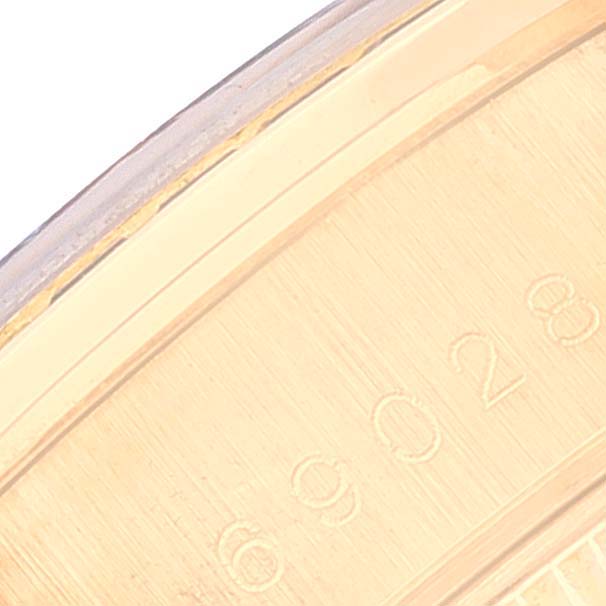 The image shows a close-up of the side of a Rolex President 69028 Women's Yellow Gold Mother of Pearl Dial 69028 Women's Yellow Gold Mother of Pearl Dial model, focusing on the engraved serial numbers.