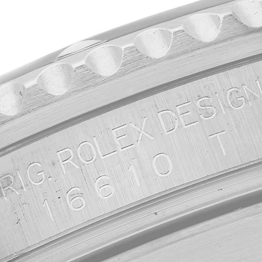 The image shows a close-up of the engraved bezel and case of a Rolex Submariner 16610 Men
s Stainless Steel Black Dial 16610 Men
s Stainless Steel Black Dial watch, including the model number.