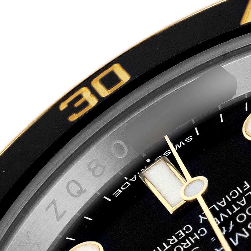 This image shows a close-up of the edge of a Rolex Submariner 116613LN Men's Steel and Gold (two tone) Black Dial's bezel and dial, highlighting the minute markers and part of the hands.