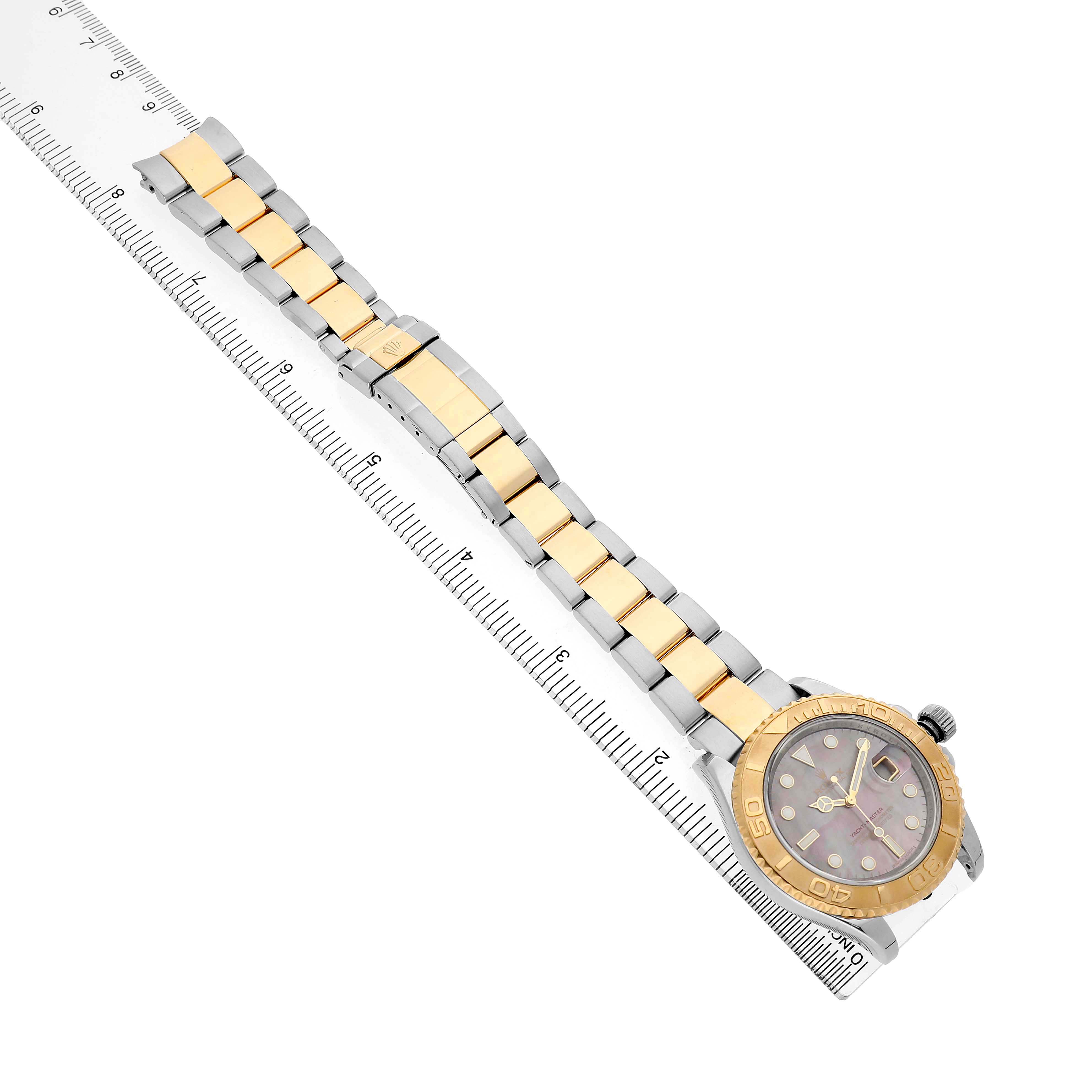 The Rolex Yacht-Master 16623 Men's Stainless Steel Mother of Pearl Dial is shown in a top-down view, featuring the full bracelet and the watch face resting diagonally on a ruler.