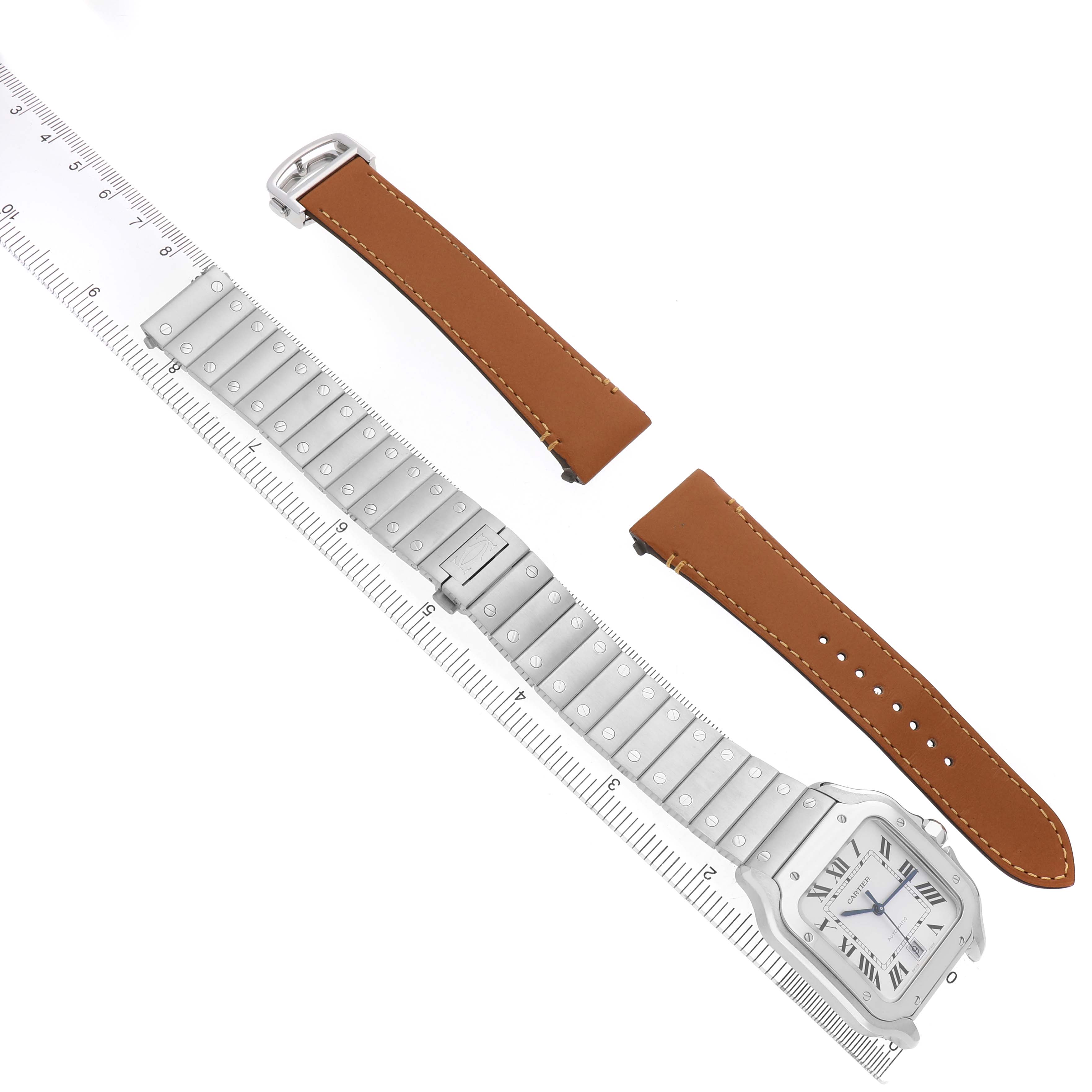 The image shows a Santos de Cartier watch with a metal bracelet, two leather strap options, and a ruler for scale, viewed from above.