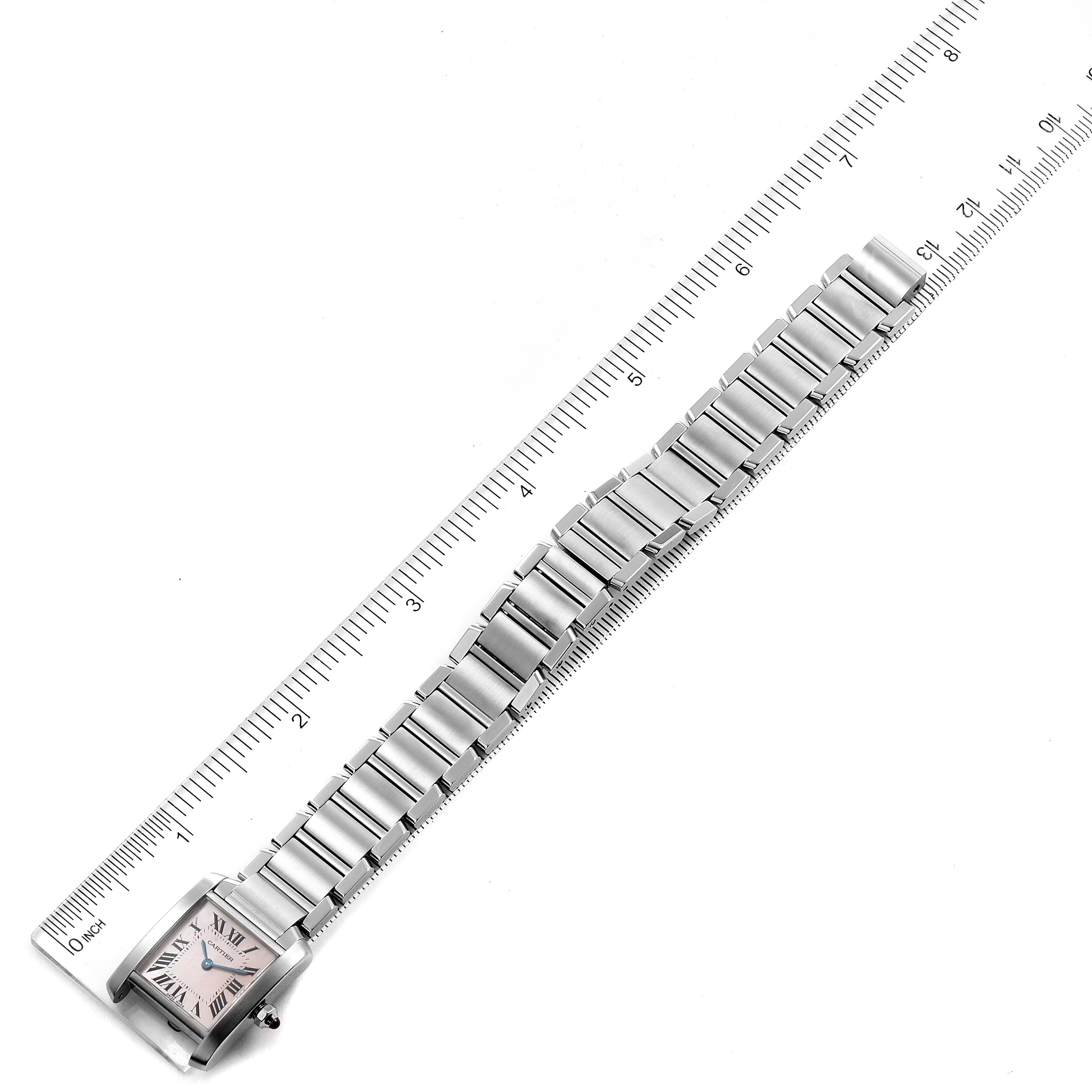 The Tank Francaise watch by Cartier is shown from an overhead angle, featuring the entire band and square face aligned with a ruler for scale.