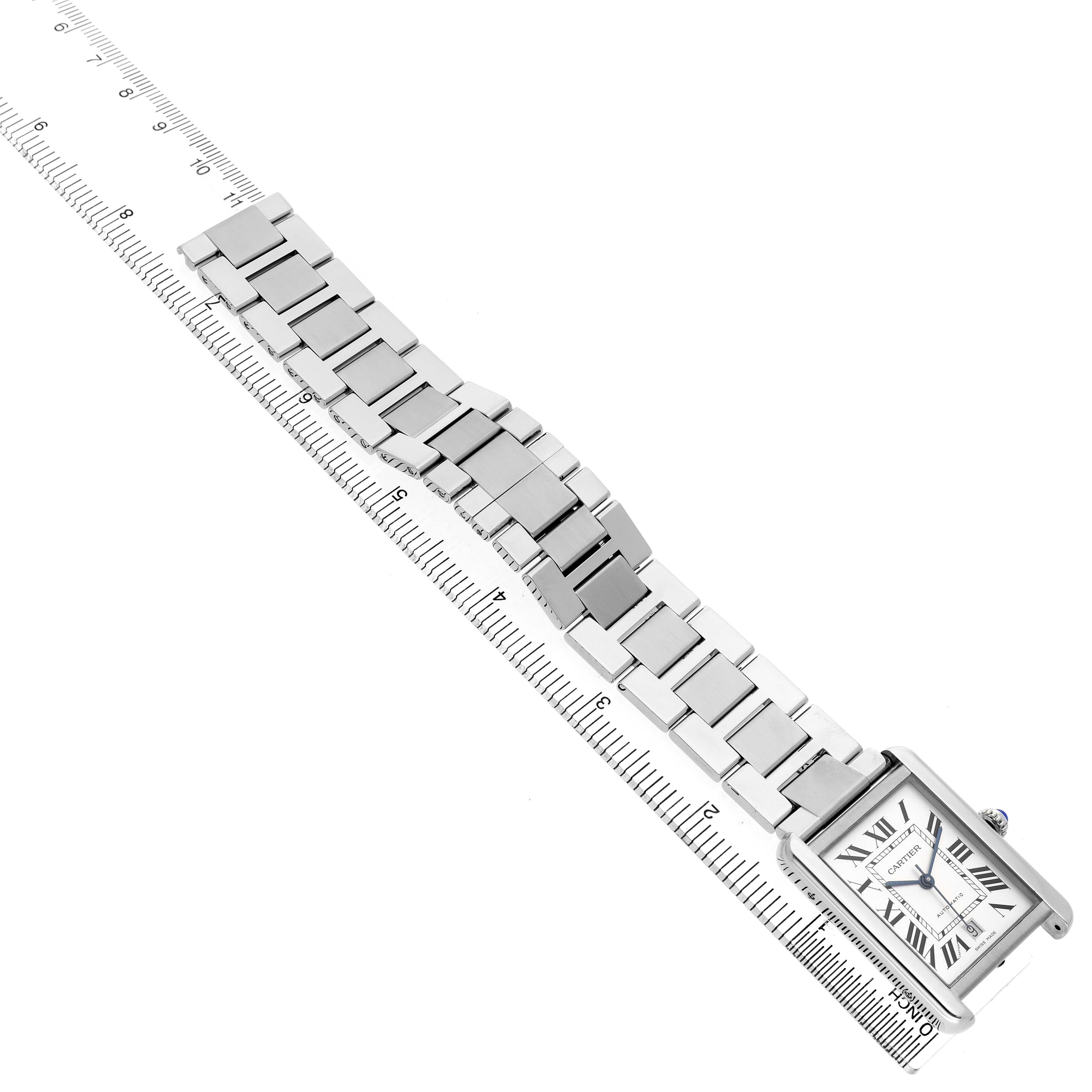 The Cartier Tank Solo W5200028 Men's Stainless Steel Silver Dial watch is shown from a top angle, highlighting the face and metal bracelet on a ruler for scale.