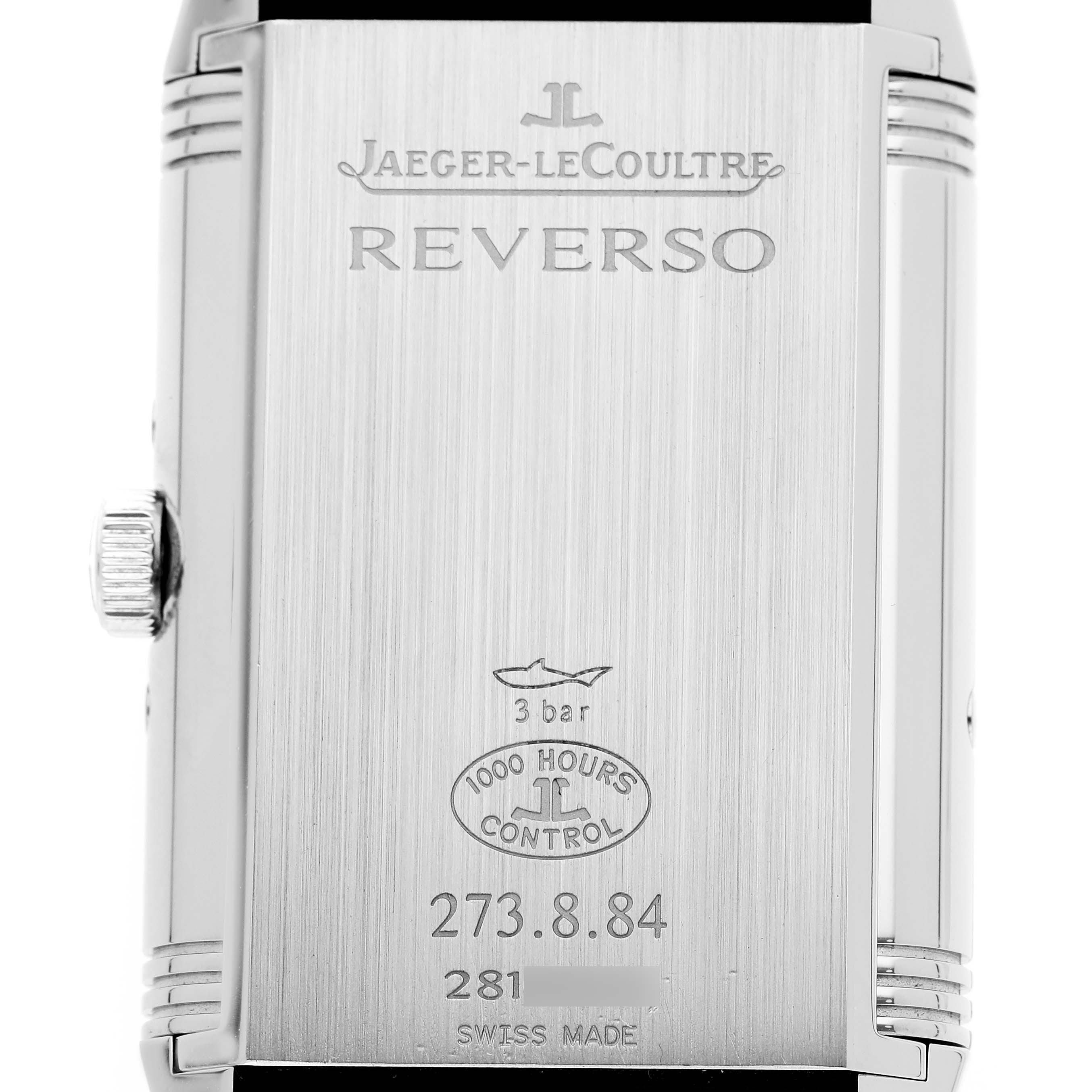 The image shows the back of a Jaeger-LeCoultre Reverso watch, displaying the logo, model name, and technical specifications.