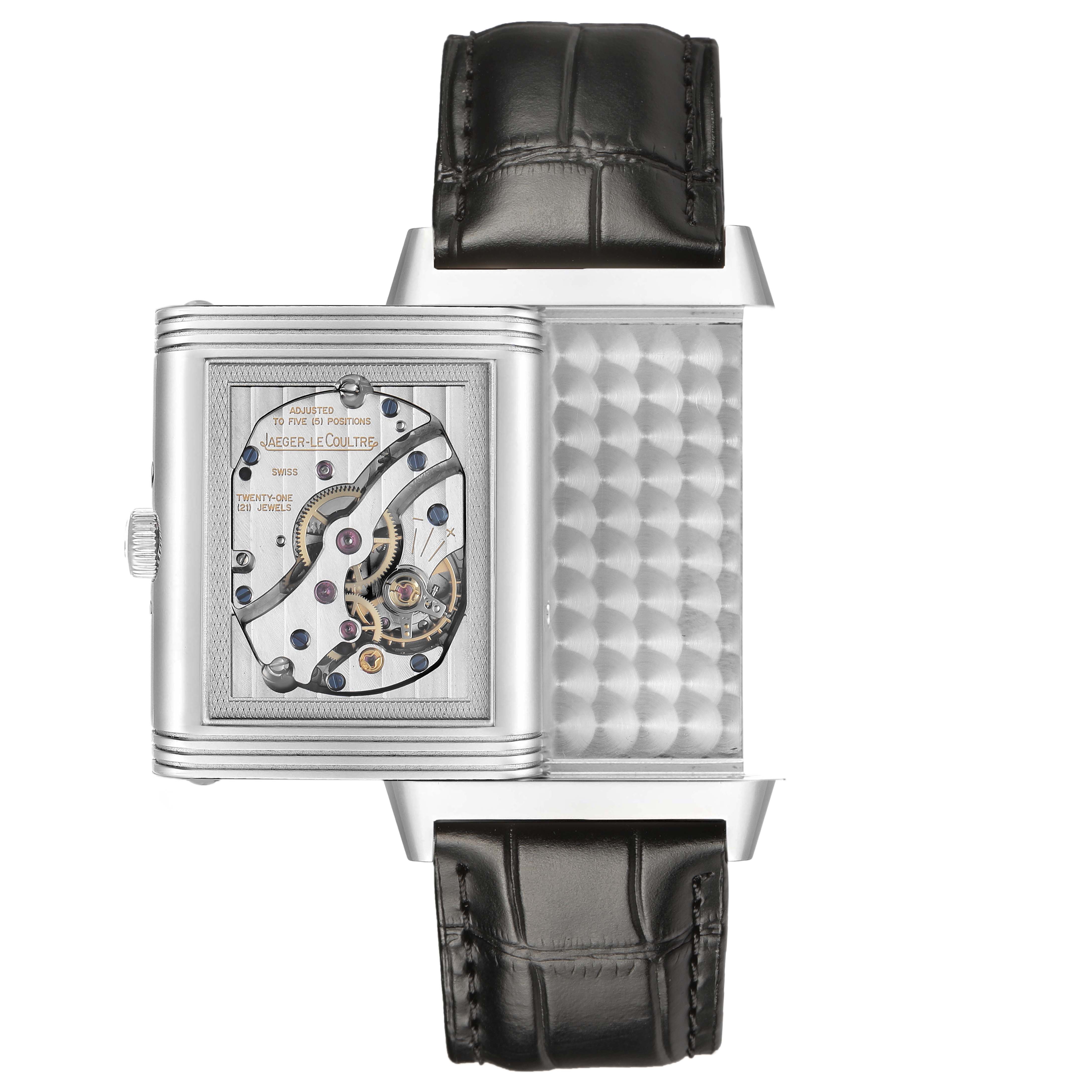 The Jaeger-LeCoultre Reverso watch is shown from the side with its case flipped, revealing the internal mechanism.