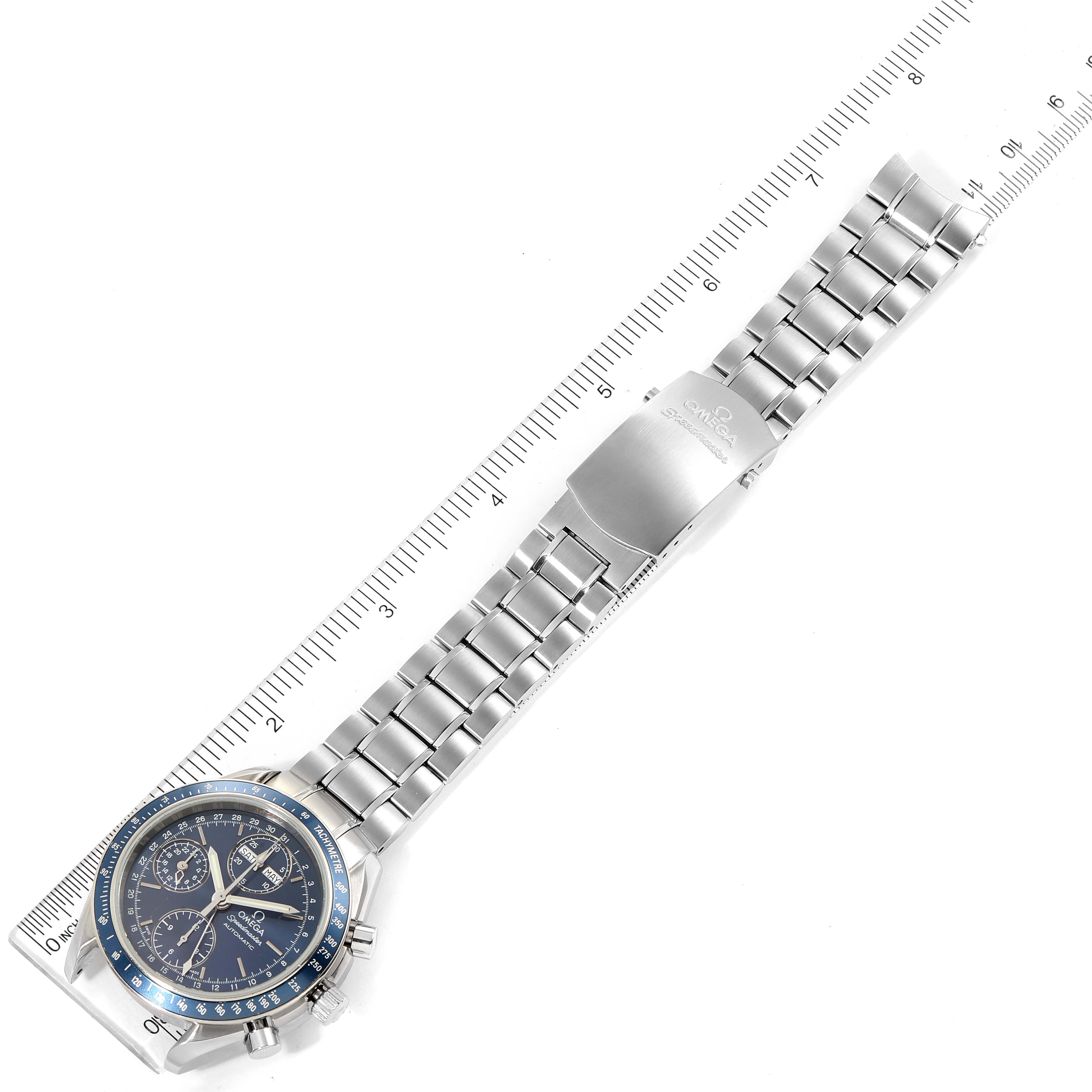 The image shows the Omega Speedmaster 3222.80.00 Men
s Stainless Steel Blue Dial 3222.80.00 Men
s Stainless Steel Blue Dial watch laid flat alongside a ruler, highlighting its face, bracelet, and clasp.