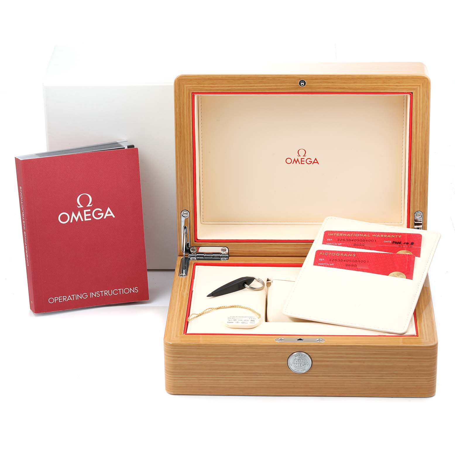 The image shows an Omega Speedmaster 326.30.40.50.01.001 Men
s Stainless Steel Black Dial 326.30.40.50.01.001 Men
s Stainless Steel Black Dial box and accessories, including operating instructions, warranty cards, a magnifier, and a tool.