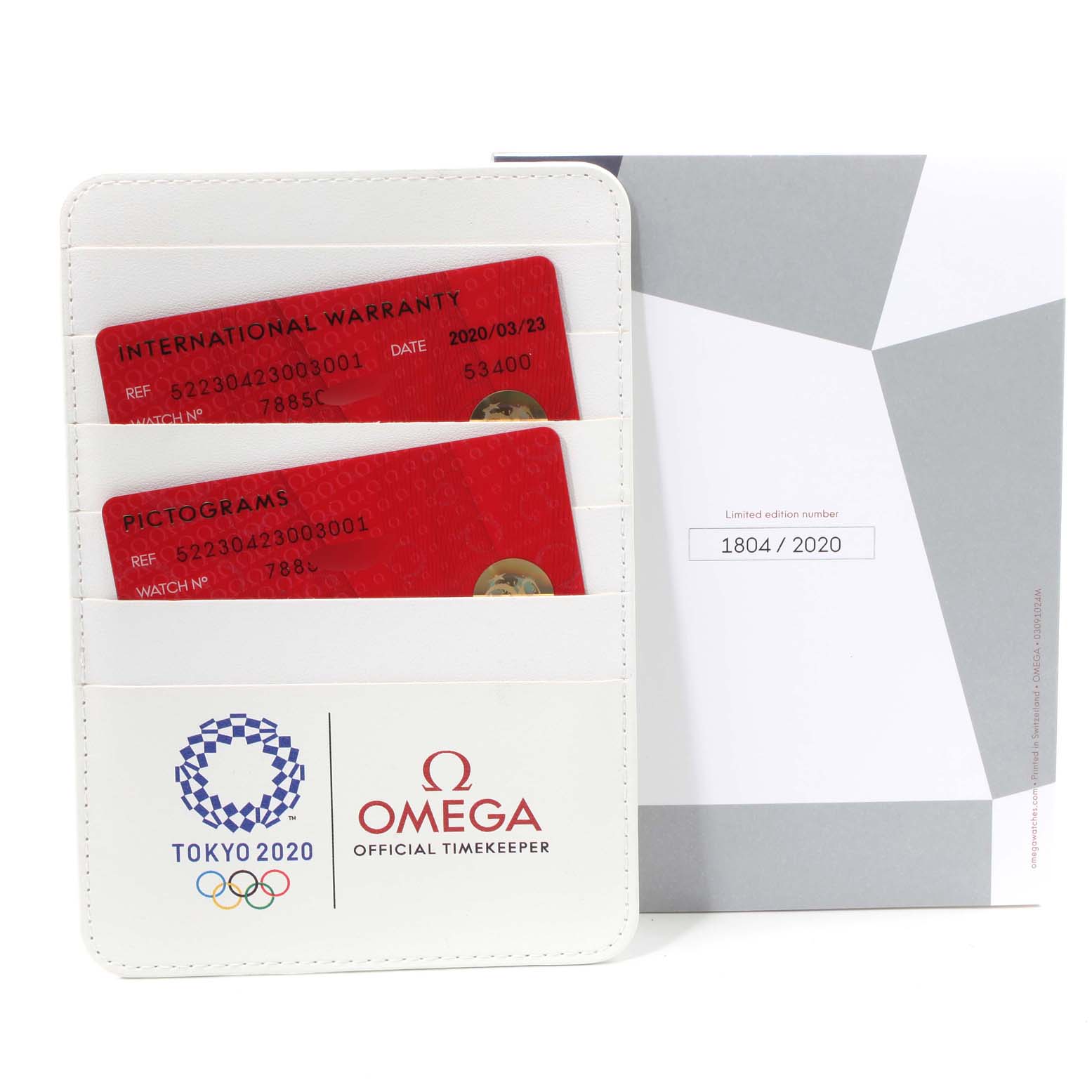The image shows warranty cards and documentation for the Omega Speedmaster 522.30.42.30.03.001 Men's Stainless Steel Blue Dial 522.30.42.30.03.001 Men's Stainless Steel Blue Dial Tokyo 2020 limited edition model, with no angle of the watch itself.