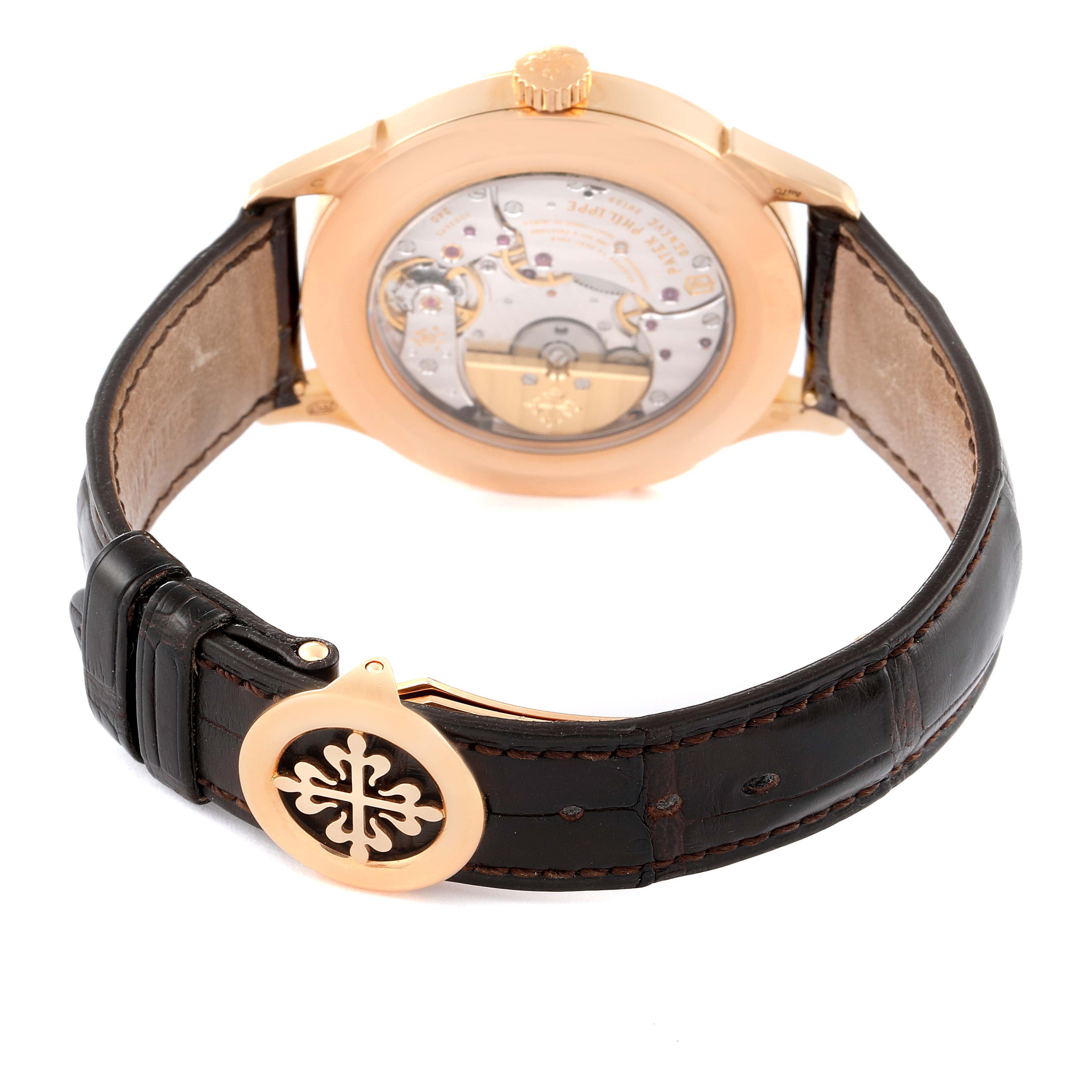 This image shows the back angle of a Patek Philippe Complications 5230R Men's Rose Gold Grey Dial 5230R Men's Rose Gold Grey Dial watch, featuring its transparent case back and leather strap with a decorative clasp.