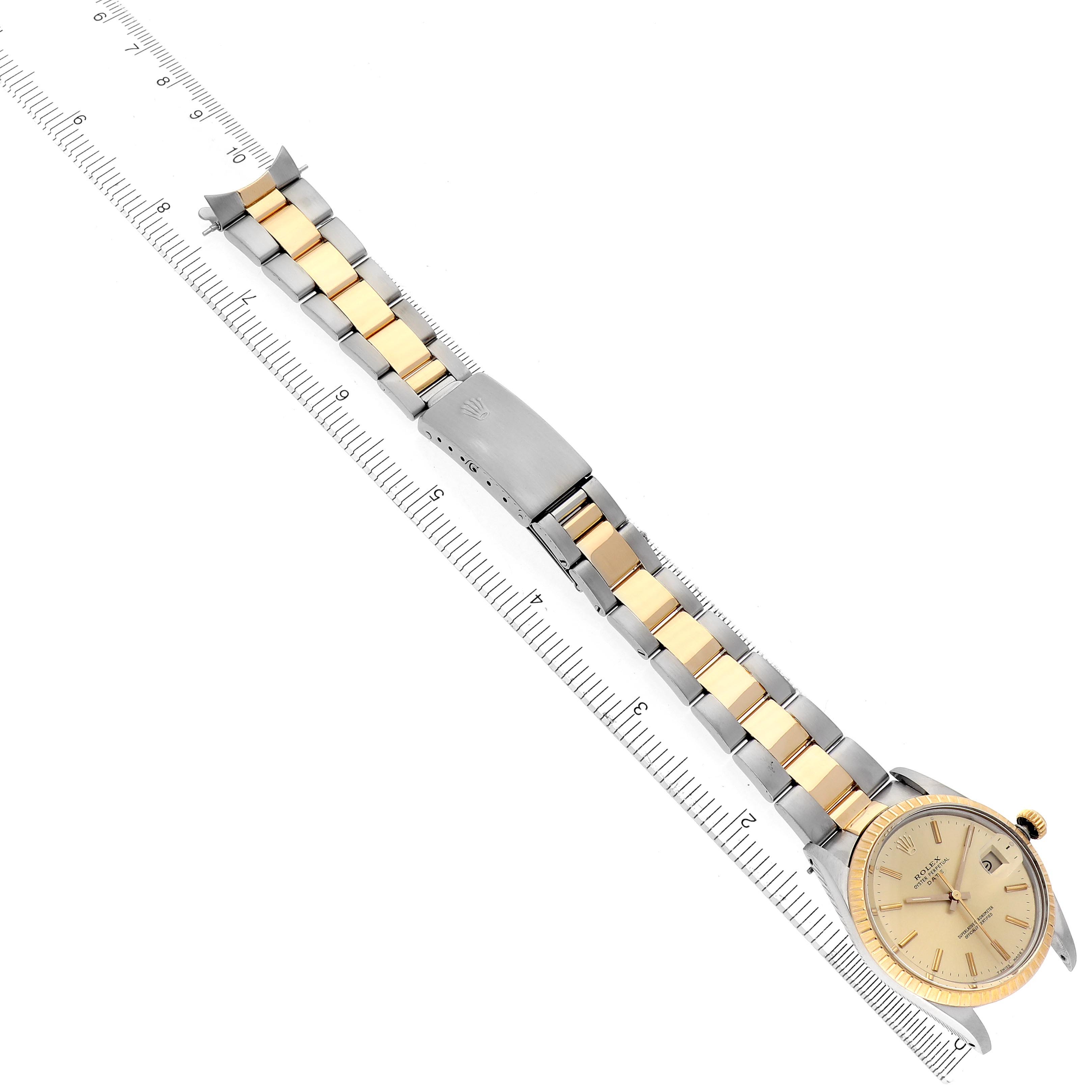 The image shows a Rolex Date 15053 Men
s Steel and Gold (two tone) Champagne Dial 15053 Men
s Steel and Gold (two tone) Champagne Dial watch laid flat, highlighting the two-tone bracelet and clasp alongside a ruler for size reference.