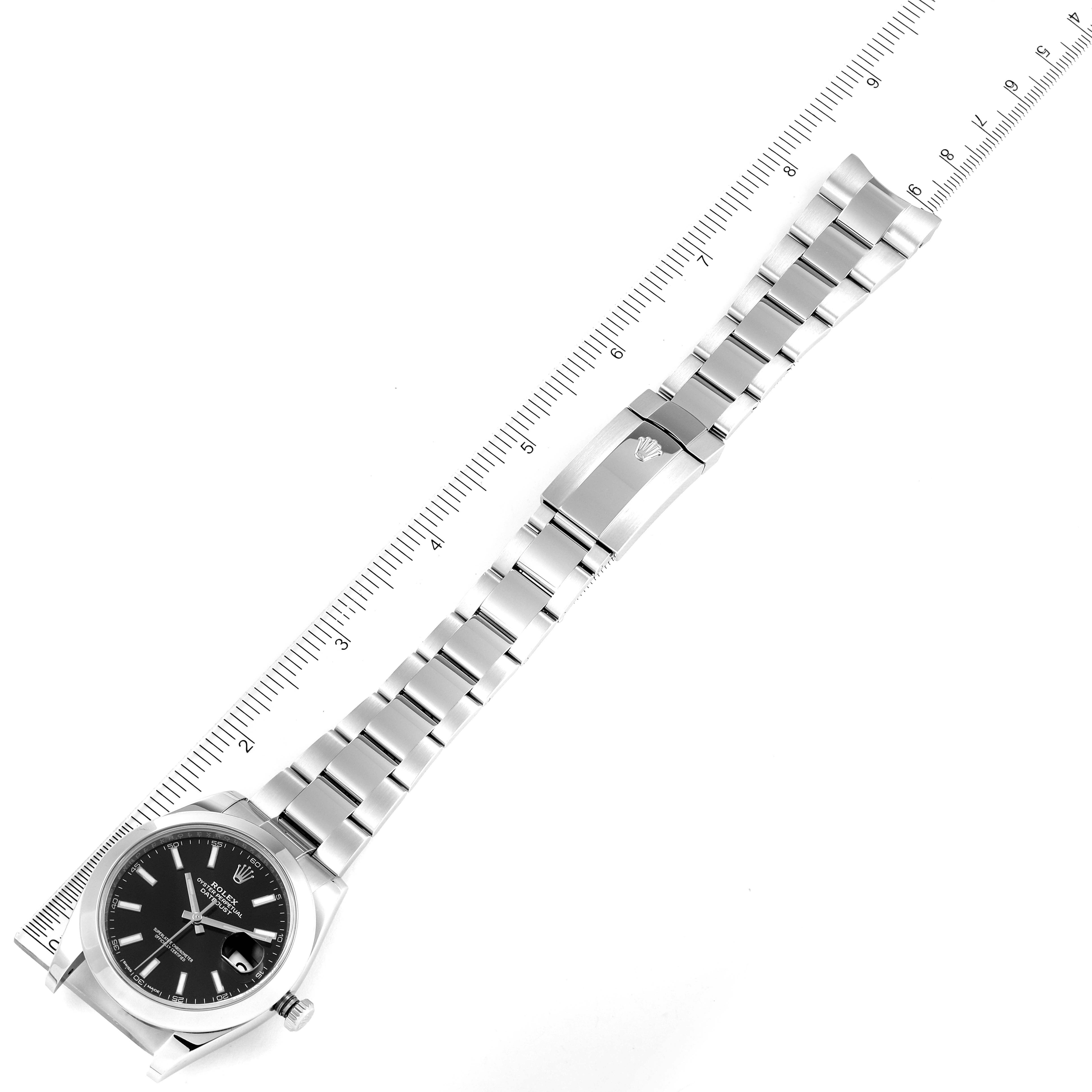 The image shows a Rolex Datejust 41 126300 Men
s Stainless Steel Black Dial 126300 Men
s Stainless Steel Black Dial watch laid flat with a ruler beside it for scale.