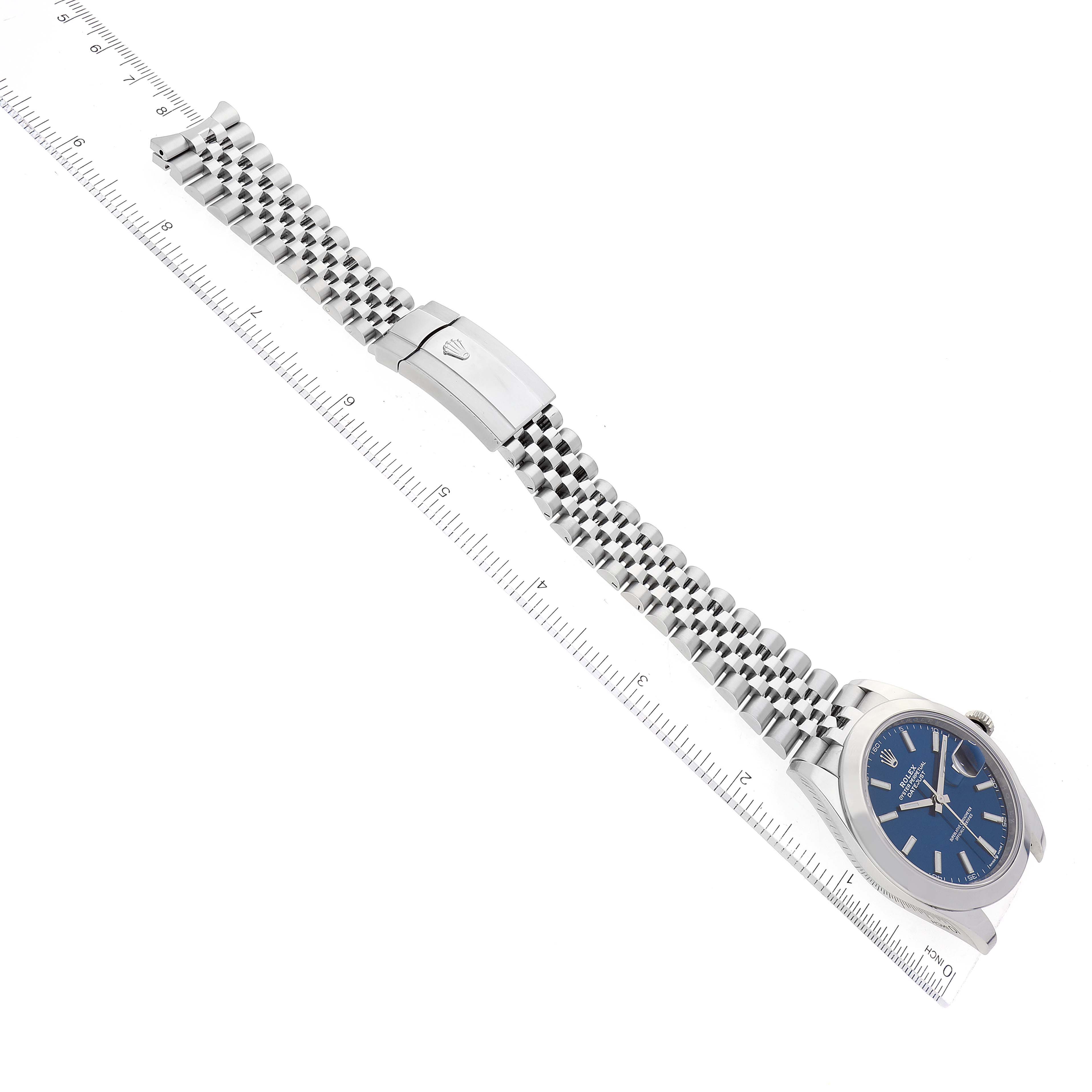 The image shows a Rolex Datejust 41 126300 Men's Stainless Steel Blue Dial 126300 Men's Stainless Steel Blue Dial watch laid flat with its blue dial, jubilee bracelet, and clasp, next to a ruler for scale.