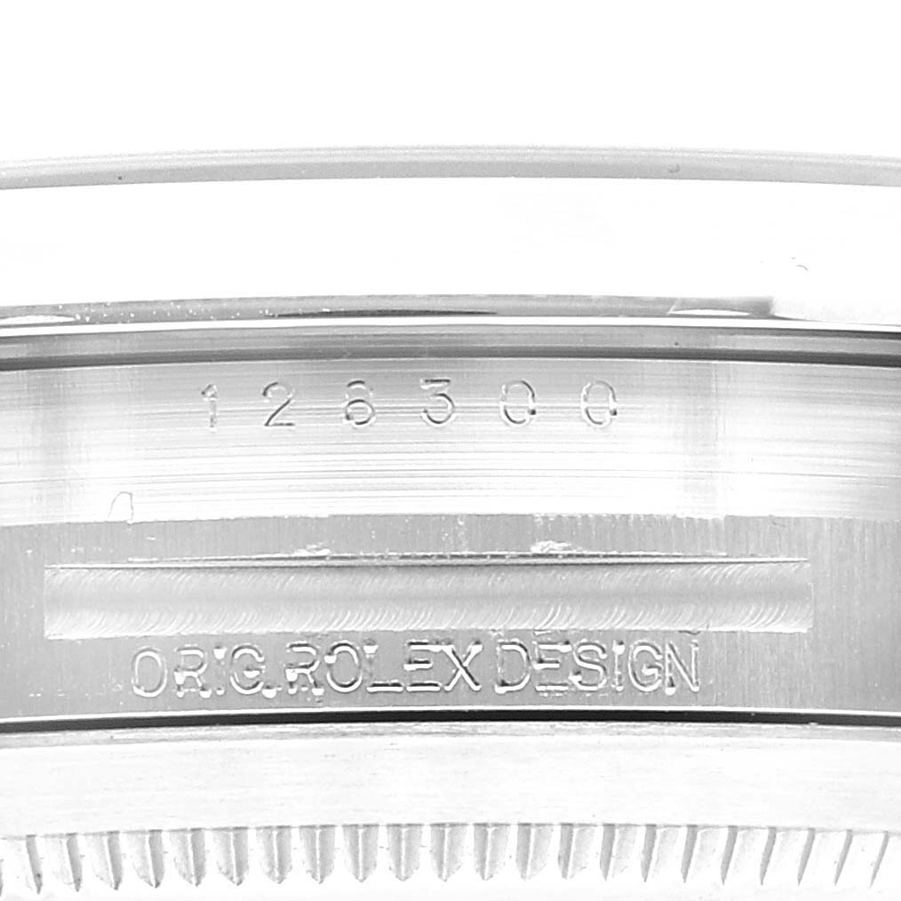 The image shows the side view of the case of a Rolex Datejust 41 126300 Men's Stainless Steel Blue Dial 126300 Men's Stainless Steel Blue Dial watch, featuring the serial number and "ORIG ROLEX DESIGN" engraving.