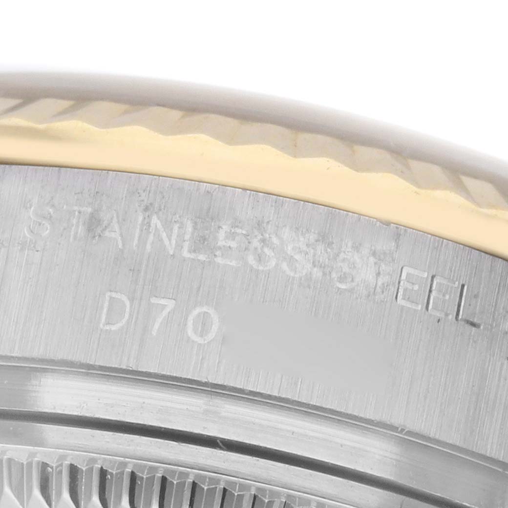 The image shows a close-up of the Rolex Datejust 179173 Women
s Steel and Gold (two tone) Silver Dial 179173 Women
s Steel and Gold (two tone) Silver Dial
s bezel and part of the stainless steel case with engraved details.