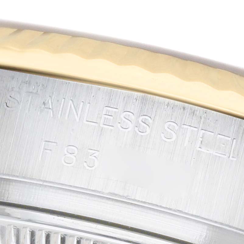 The image shows a close-up of a Datejust Rolex watch's stainless steel case with engraved text.