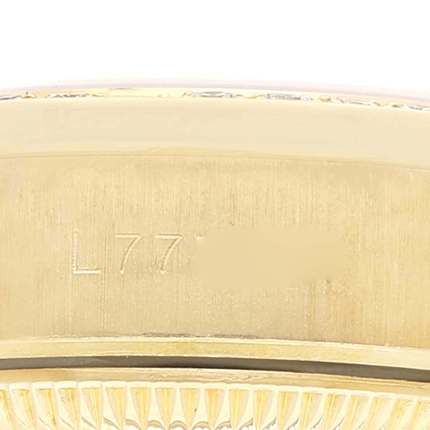 The image shows a close-up angle of the Rolex President 69158 Women
s Yellow Gold Champagne Dial 69158 Women
s Yellow Gold Champagne Dial model watch’s case edge, featuring engraving details and part of the bezel.