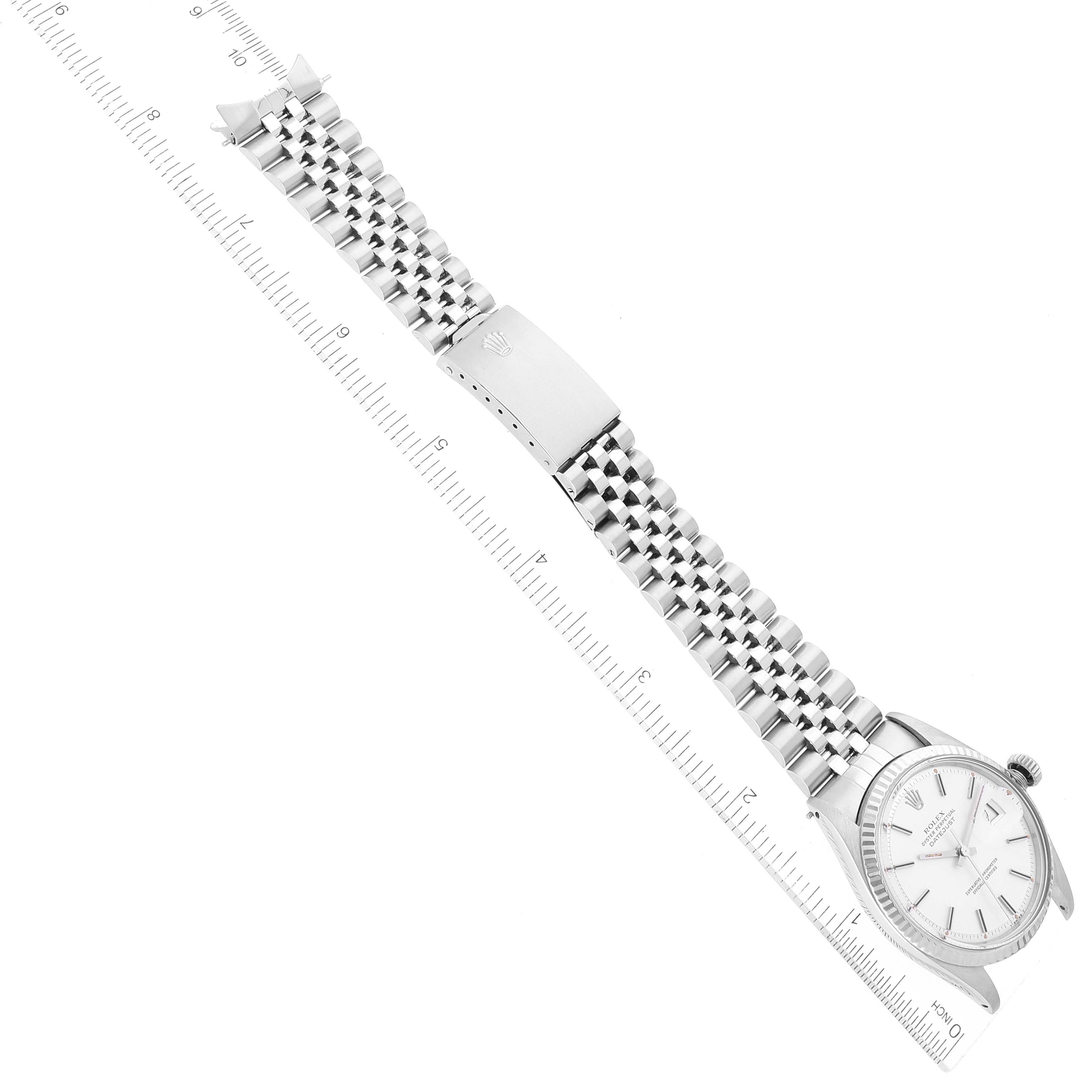 The image shows a top-down view of a Rolex Vintage Collection 1601 Men's Stainless Steel Silver Dial 1601 Men's Stainless Steel Silver Dial watch and its metal bracelet, along with a ruler for scale.