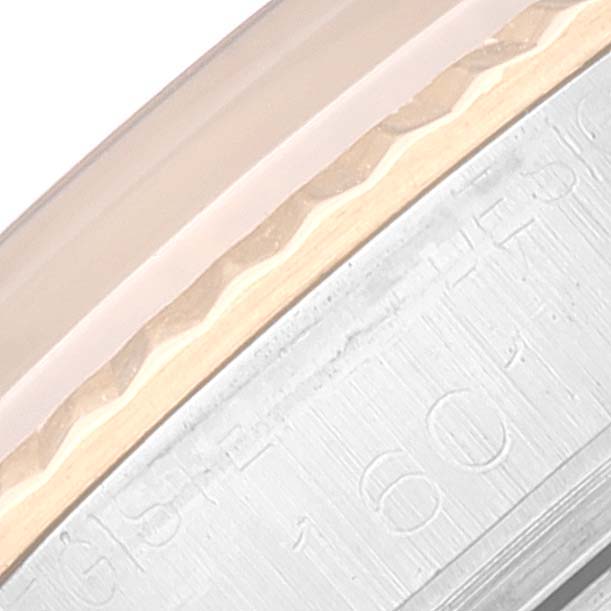 This close-up image of a Rolex Vintage Collection 1601 Men's Steel and Gold (two tone) Black Dial 1601 Men's Steel and Gold (two tone) Black Dial watch shows the edge of the bezel and engraved details on the watch case.