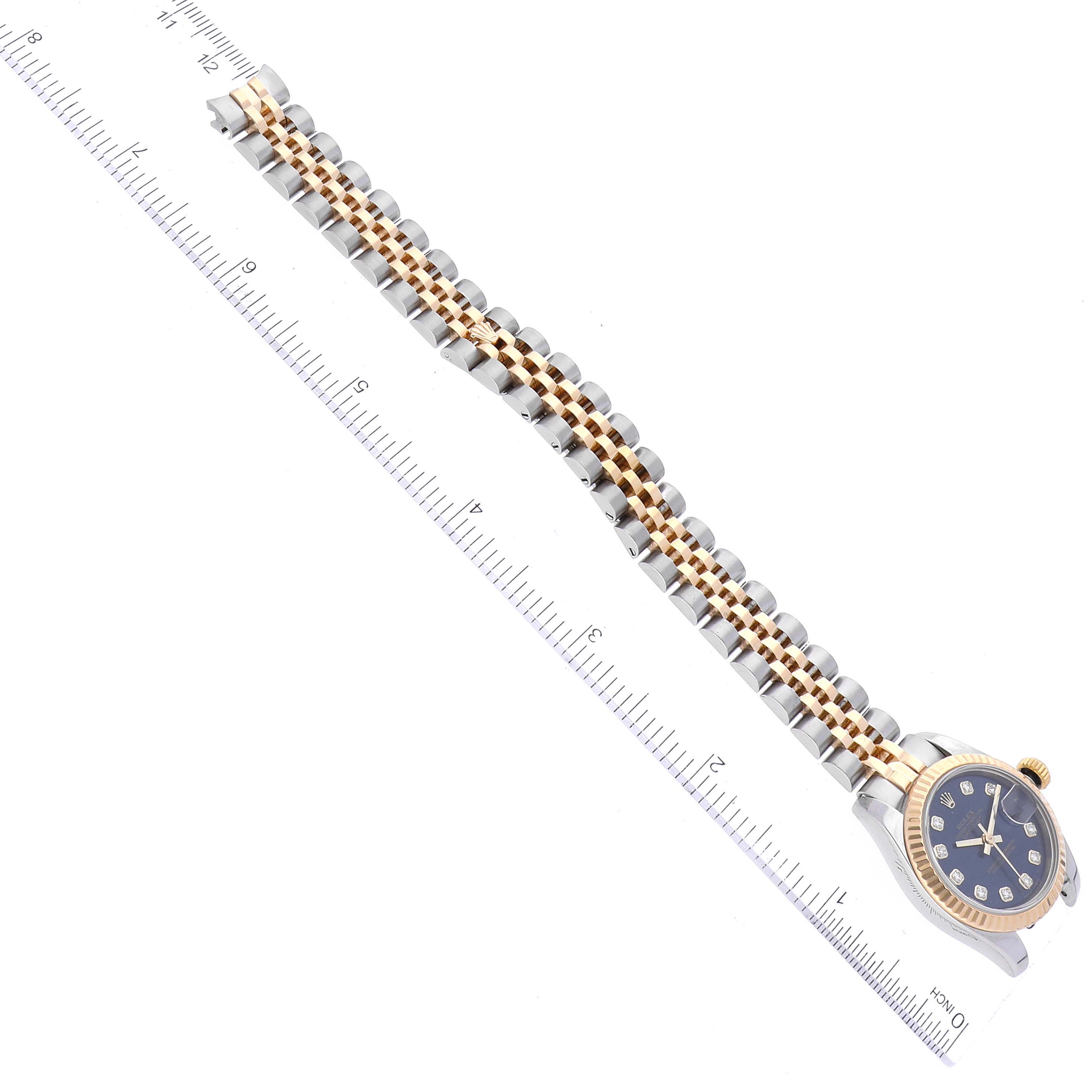 The image shows a Rolex Datejust 179173 Women's Steel and Gold (two tone) Blue Dial 179173 Women's Steel and Gold (two tone) Blue Dial watch laid flat with its band extended, alongside a ruler for measurement.