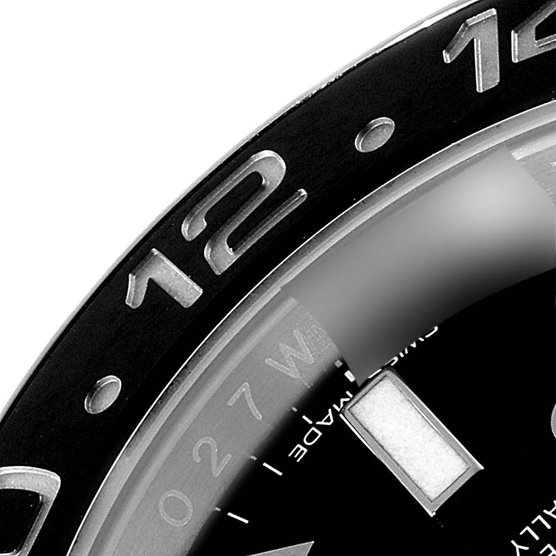 The image shows a close-up of the bezel and a part of the dial of a Rolex GMT-Master 116710 Men's Stainless Steel Black Dial 116710 Men's Stainless Steel Black Dial watch.