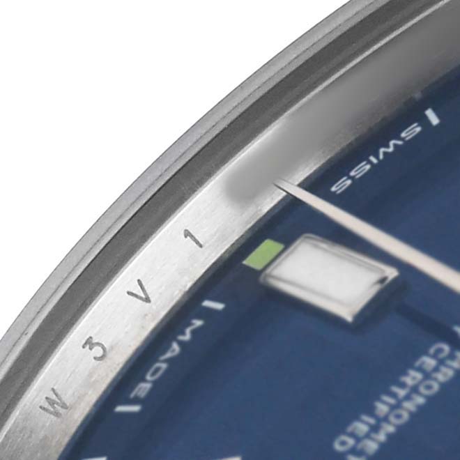 The image shows a close-up of the dial and part of the bezel of a Rolex Oyster Perpetual 114300 Men's Stainless Steel Blue Dial watch.