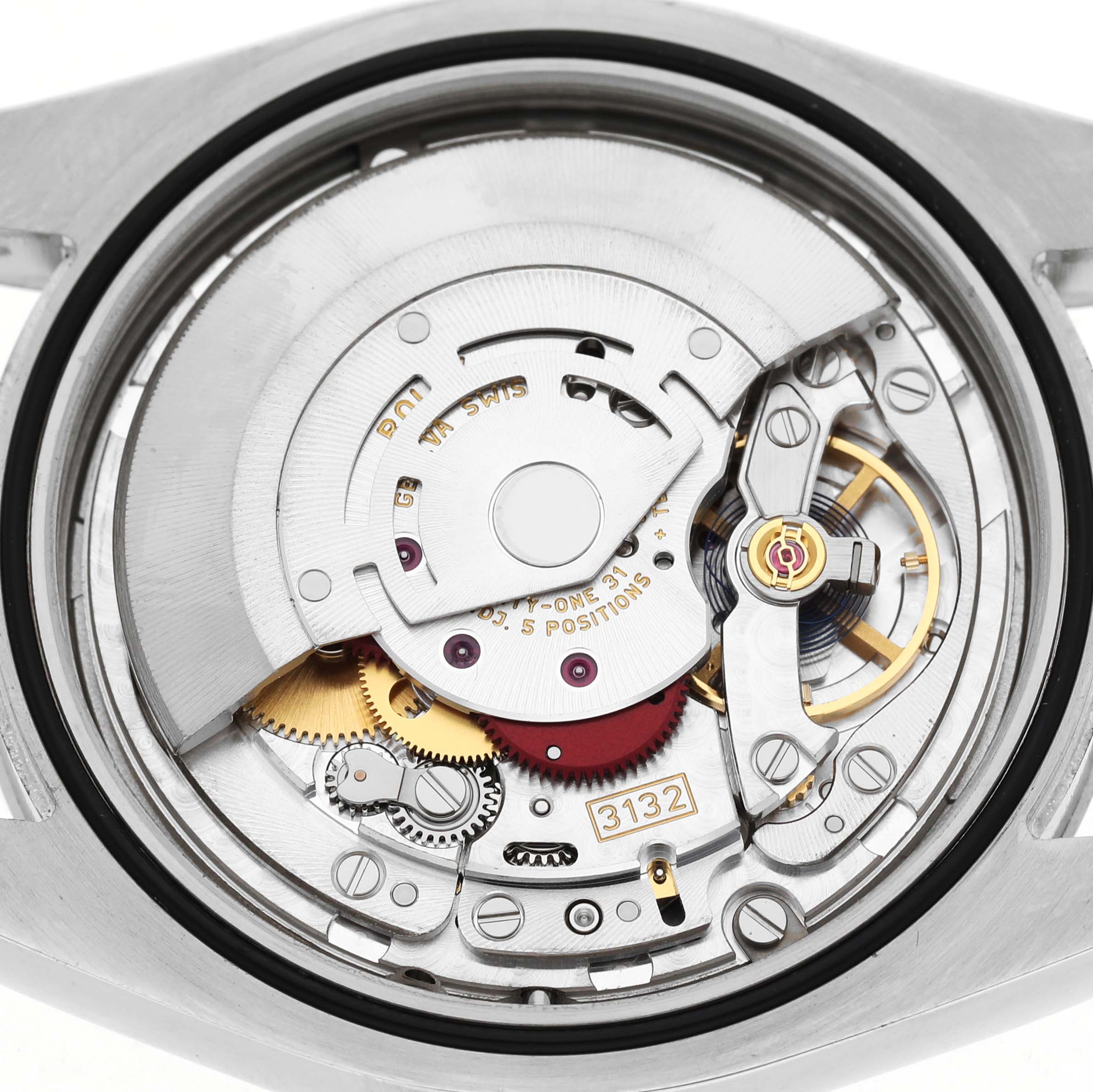 The image shows the movement mechanism of a Rolex Oyster Perpetual 114300 Men's Stainless Steel Blue Dial watch from a rear angle, highlighting gears and components.