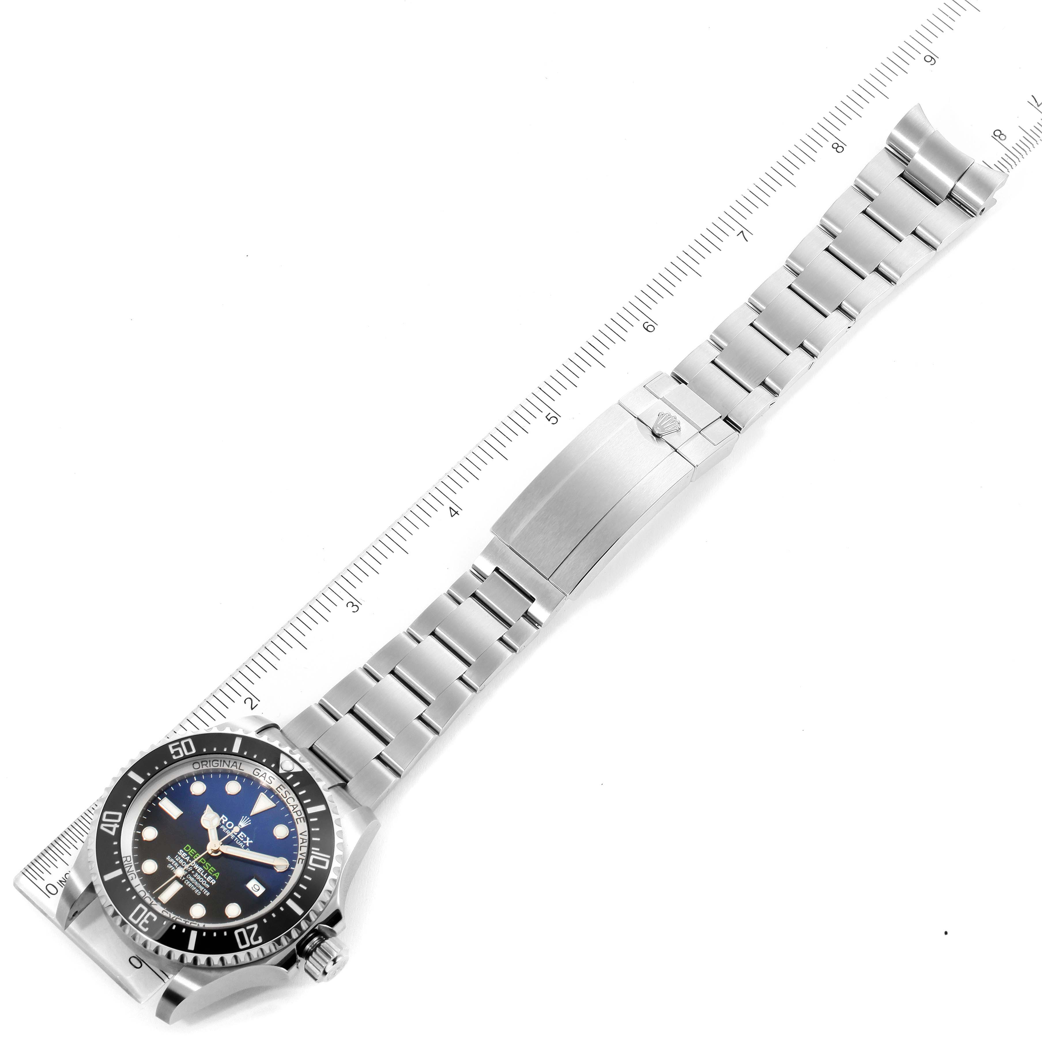 The Rolex Sea-Dweller 126660 Men
s Stainless Steel Blue Dial 126660 Men
s Stainless Steel Blue Dial watch is shown from a top-down angle, displaying the full bracelet and watch face alongside a ruler for scale.