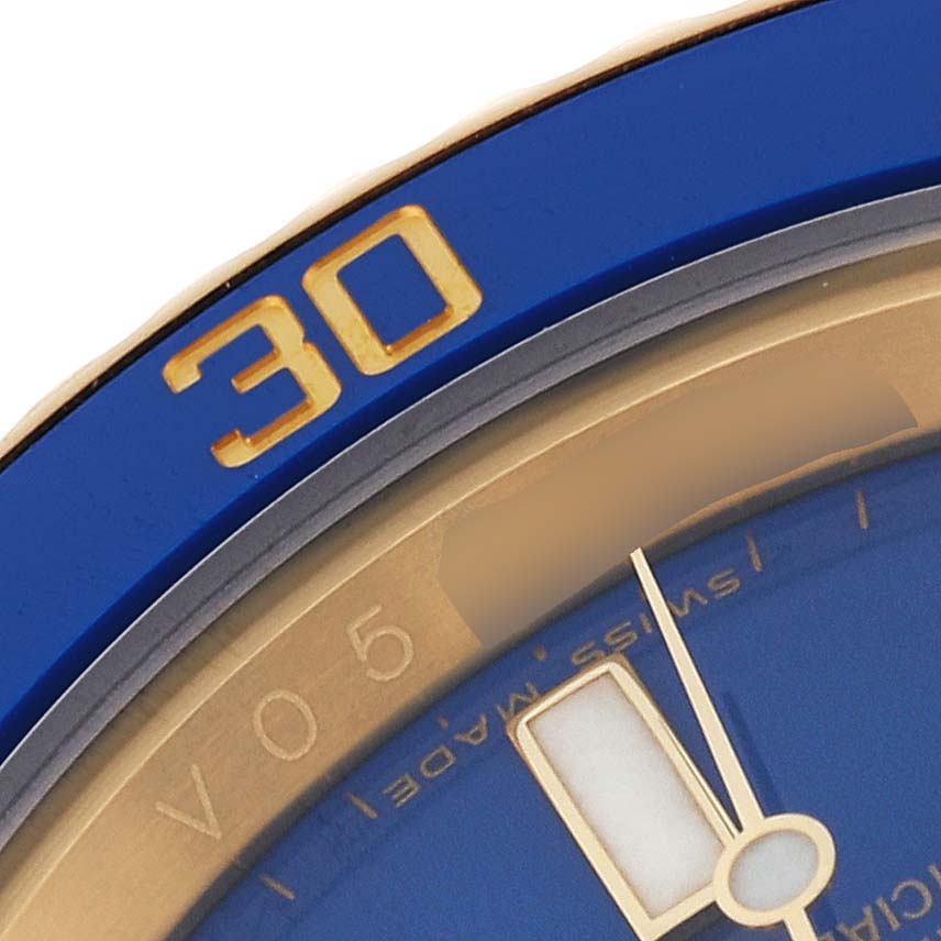 This close-up image shows the bezel, part of the dial, and the minute hand of a Rolex Submariner 116618 Men's Yellow Gold Blue Dial 116618 Men's Yellow Gold Blue Dial watch.
