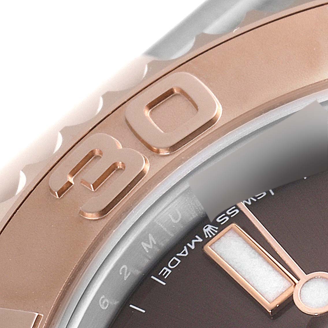 This close-up image of the Rolex Yacht-Master 268621 Men's Steel and Gold (two tone) Brown Dial 268621 Men's Steel and Gold (two tone) Brown Dial watch shows part of the rose gold bezel and a section of the watch dial with the "30" minute marker.