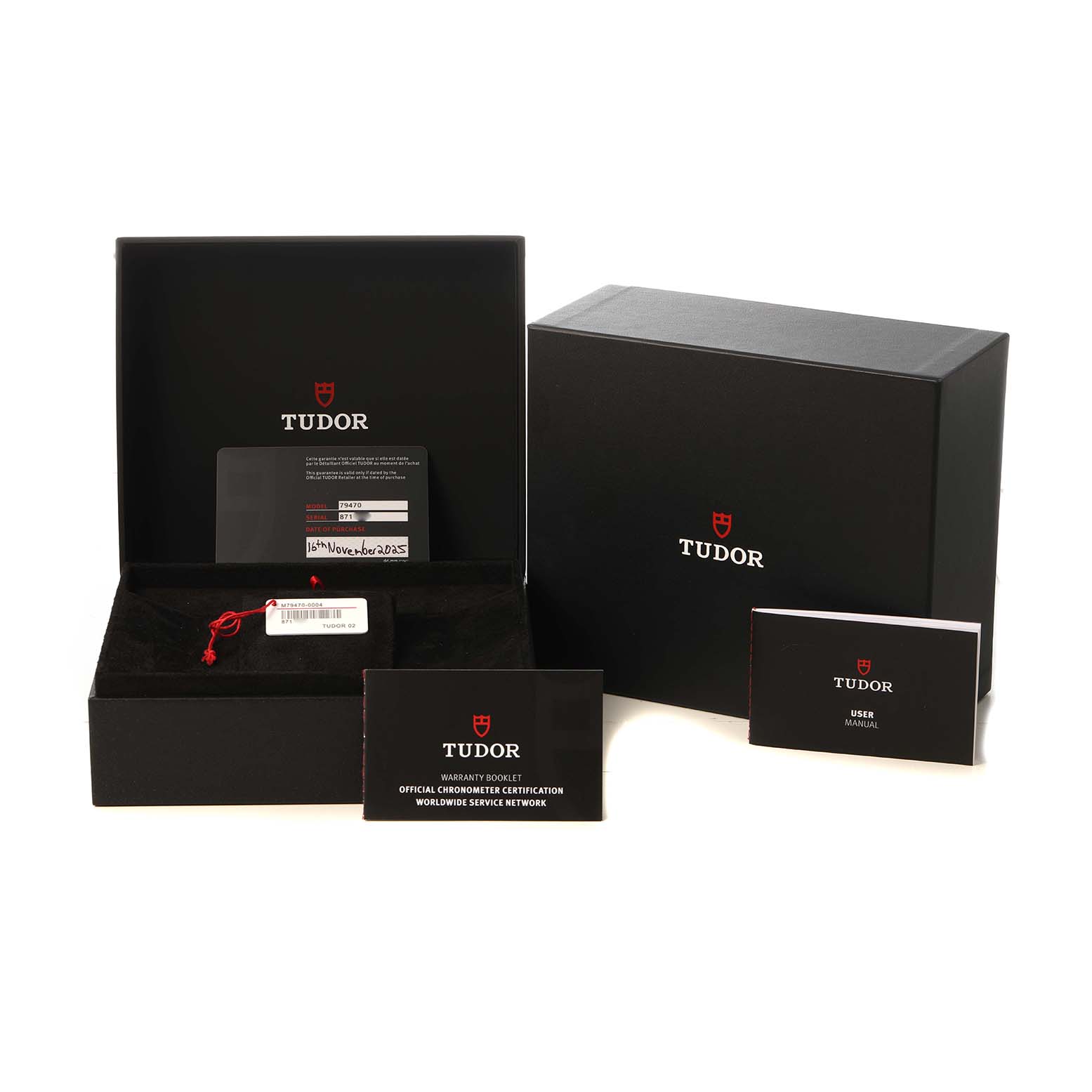 The image shows the Tudor Heritage Black Bay M79470-0004 Men's Stainless Steel White Dial packaging, including the box, warranty card, and manuals.
