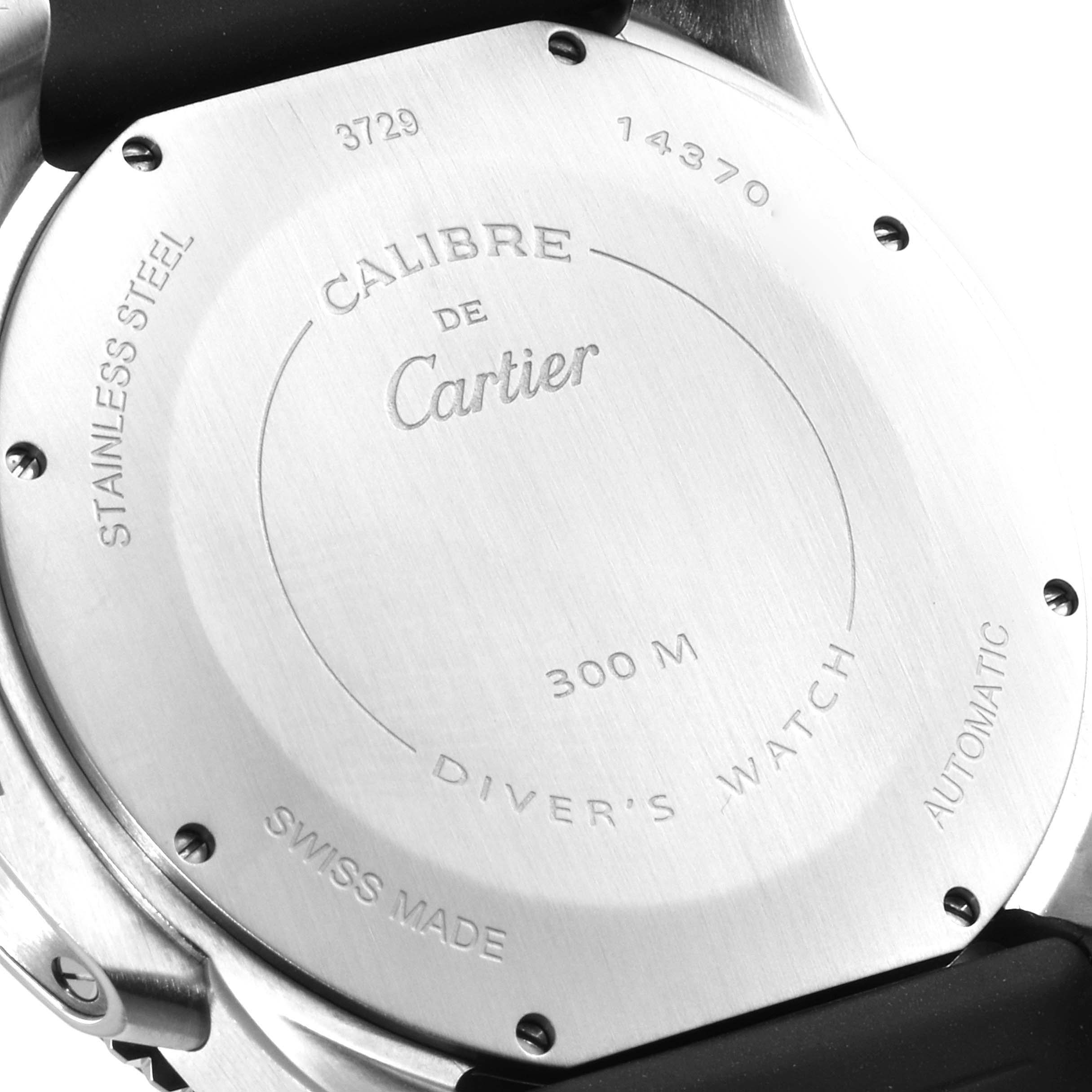 The image shows the back of a Calibre de Cartier watch by Cartier, highlighting its stainless steel case and various engravings.