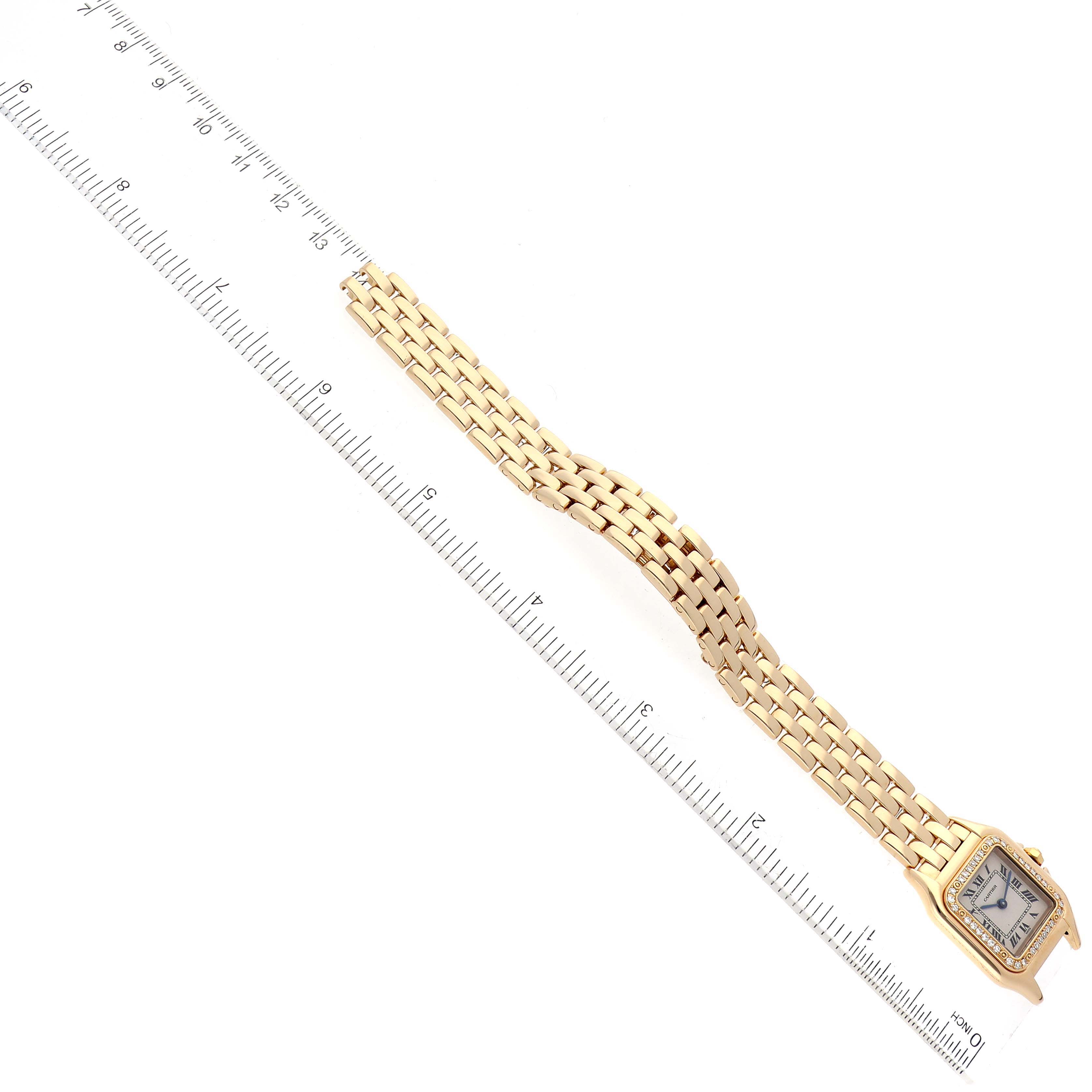 The image shows a Cartier Panthere WF3070B9 Women's Yellow Gold Silver Dial WF3070B9 Women's Yellow Gold Silver Dial watch placed against a ruler, displaying its face and gold bracelet from a top-down angle.