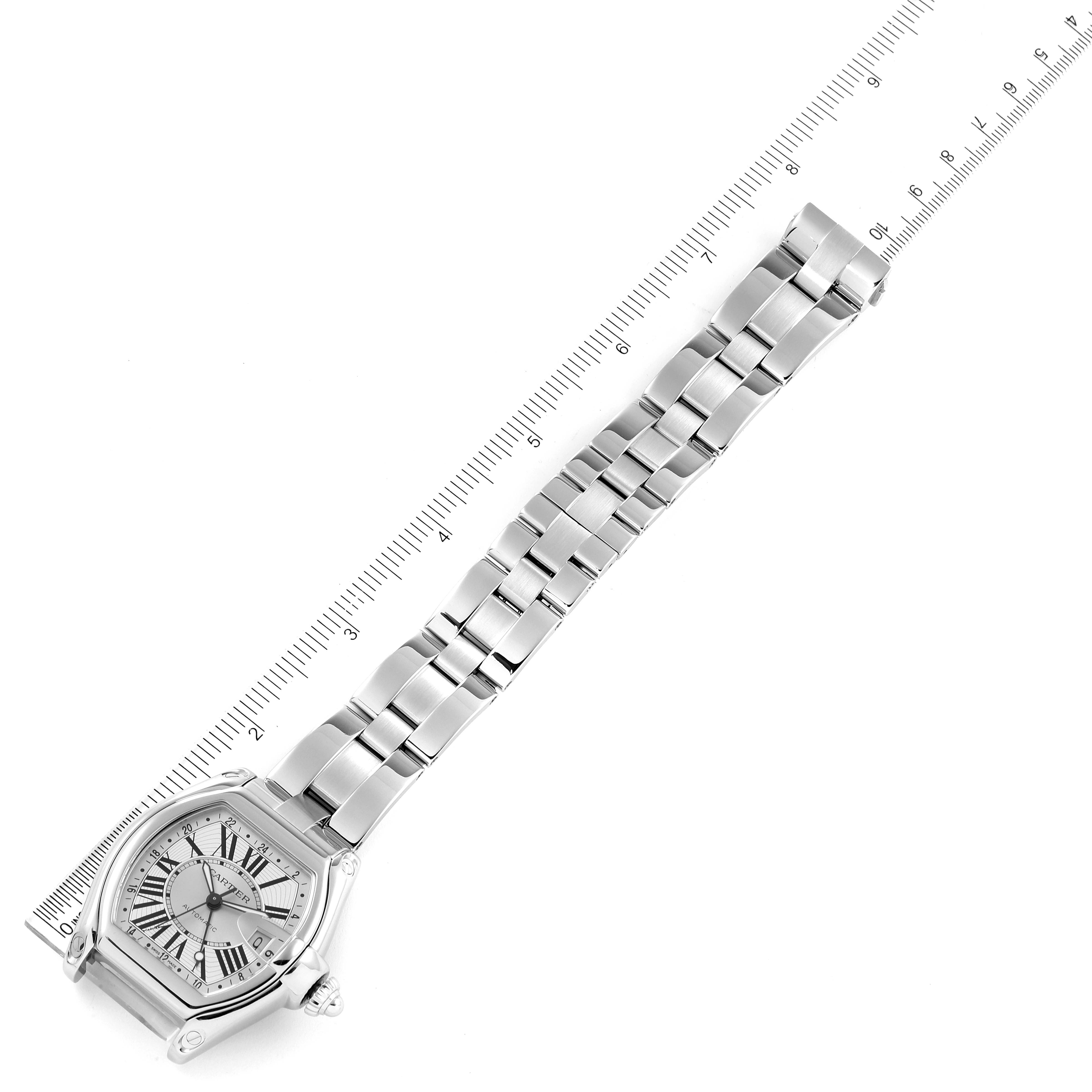 The image shows a Cartier Roadster W62032X6 Men
s Stainless Steel Silver Dial W62032X6 Men
s Stainless Steel Silver Dial watch face and bracelet at an angled top-down view with a ruler alongside.