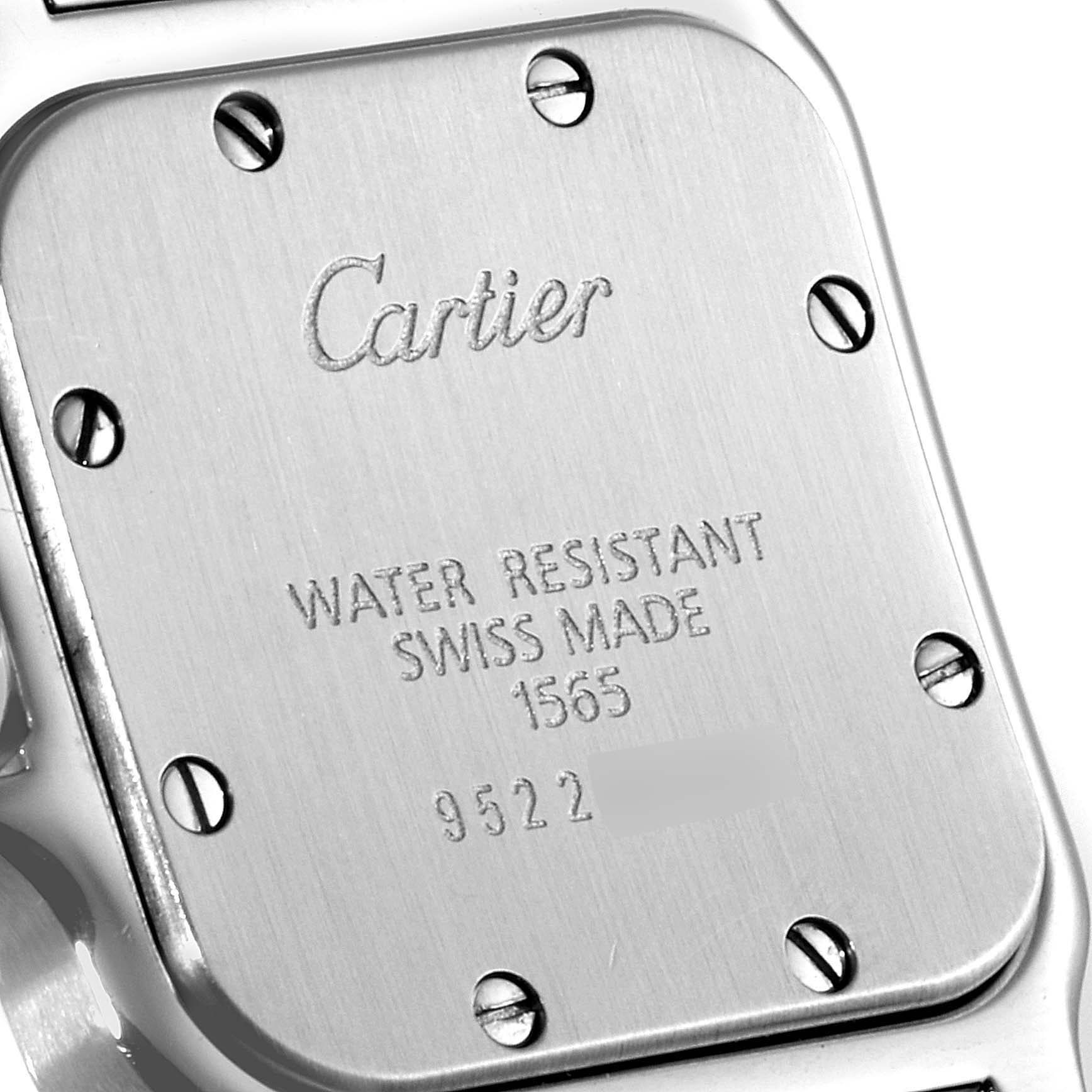 This image shows the back case of a Santos model watch by Cartier, highlighting its screws and engraved details.