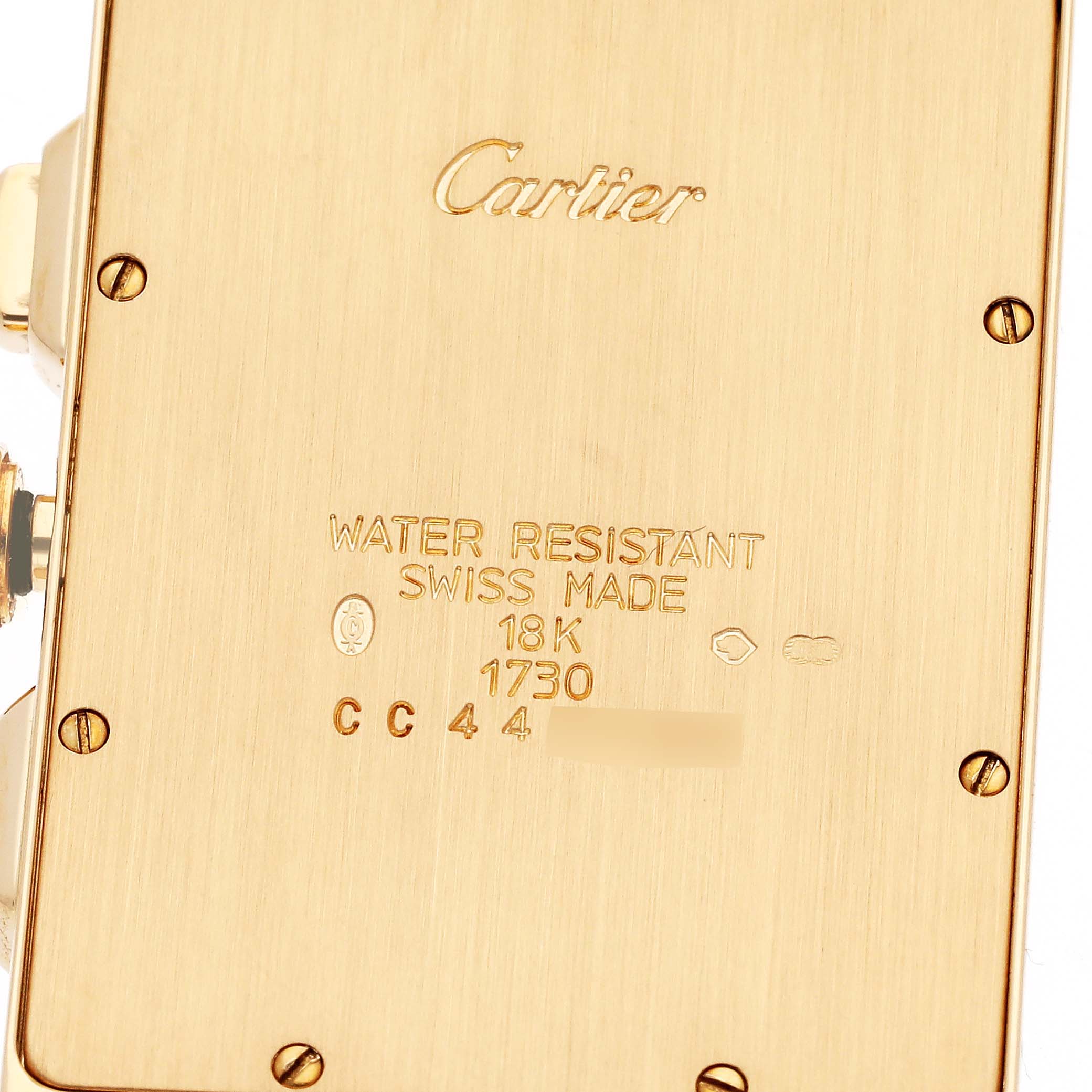The image shows the back casing of a Cartier Tank Americaine W26011K2 Men
s Yellow Gold Silver Dial W26011K2 Men
s Yellow Gold Silver Dial watch, highlighting inscriptions and screws.