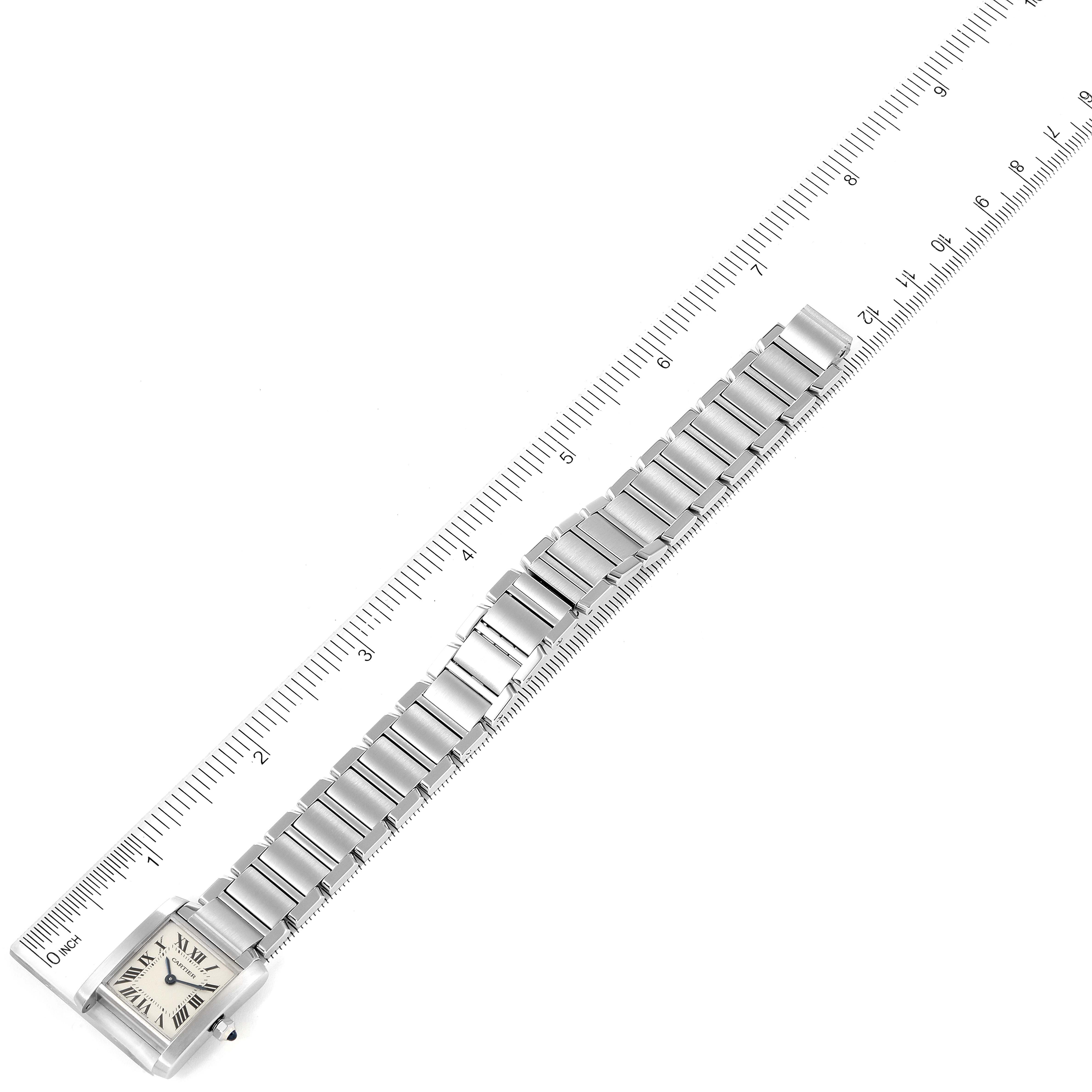 The image shows the Cartier Tank Francaise W51008Q3 Women's Stainless Steel Silver Dial W51008Q3 Women's Stainless Steel Silver Dial watch laid flat with its face and metal bracelet visible, next to a ruler for scale.