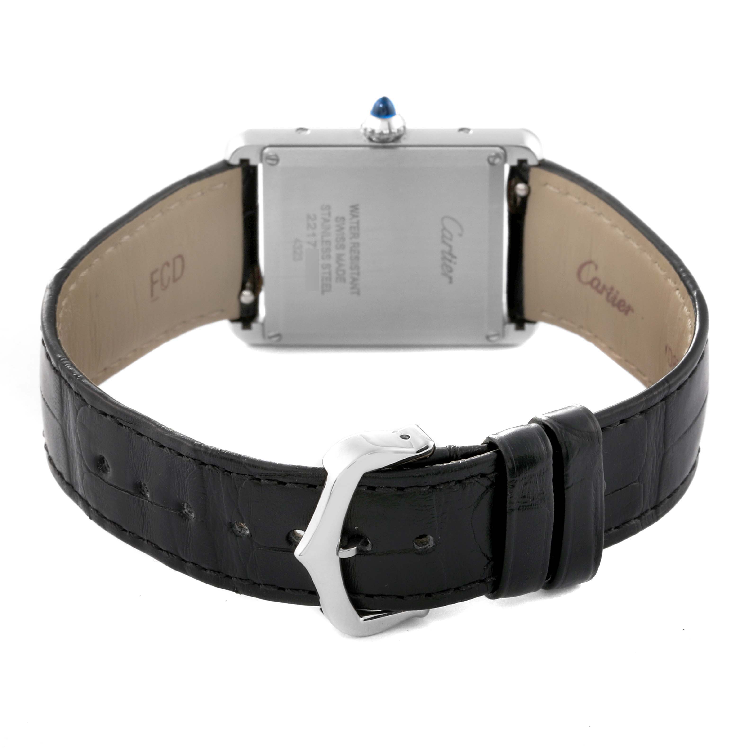The image shows the back of a Cartier Tank Must WSTA0072 Women
s Stainless Steel Black Dial WSTA0072 Women
s Stainless Steel Black Dial watch and its black leather strap with a silver buckle.