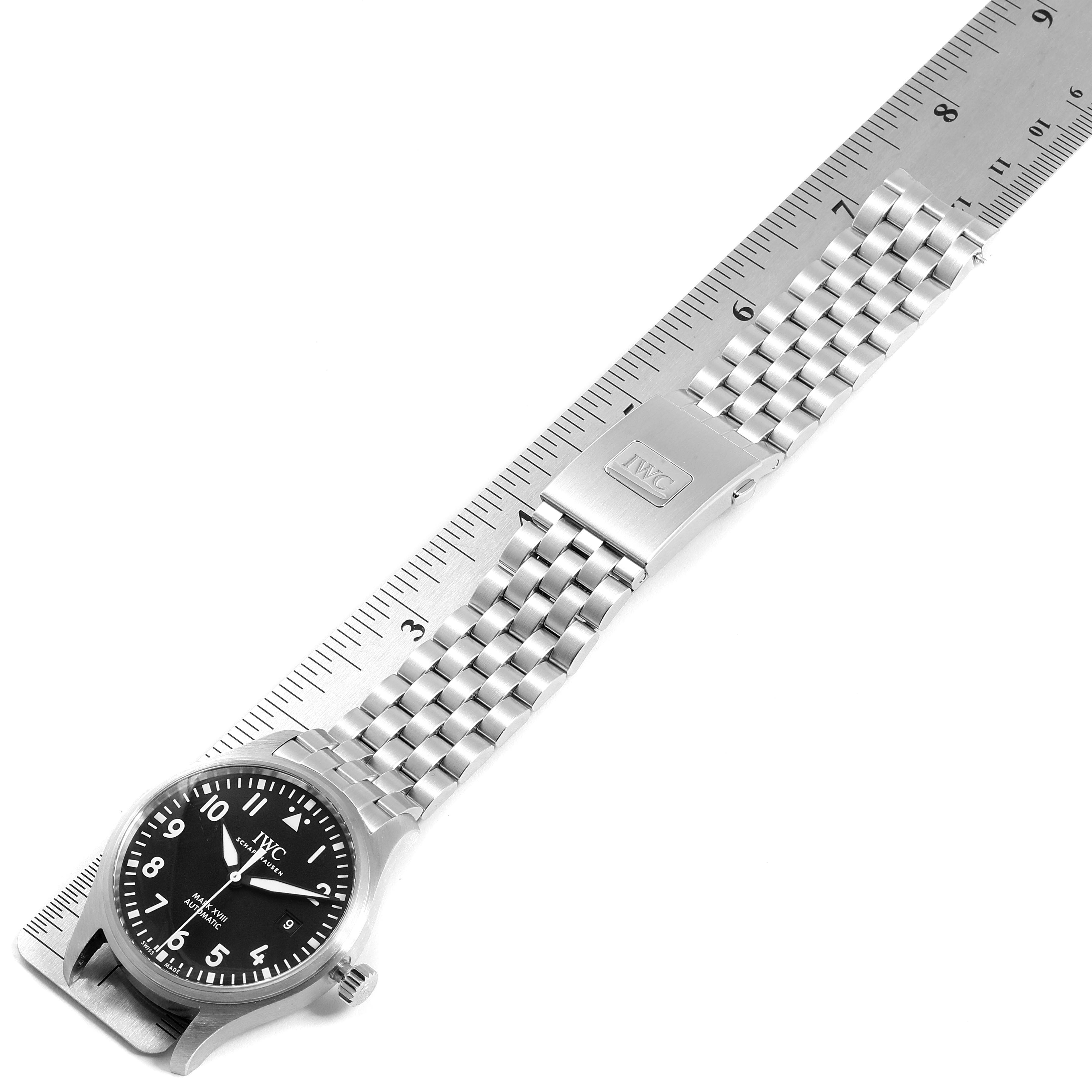 The IWC Pilot IW327011 Men's Stainless Steel Black Dial IW327011 Men's Stainless Steel Black Dial watch is shown flat with its stainless steel strap aligned next to a ruler measuring its length.