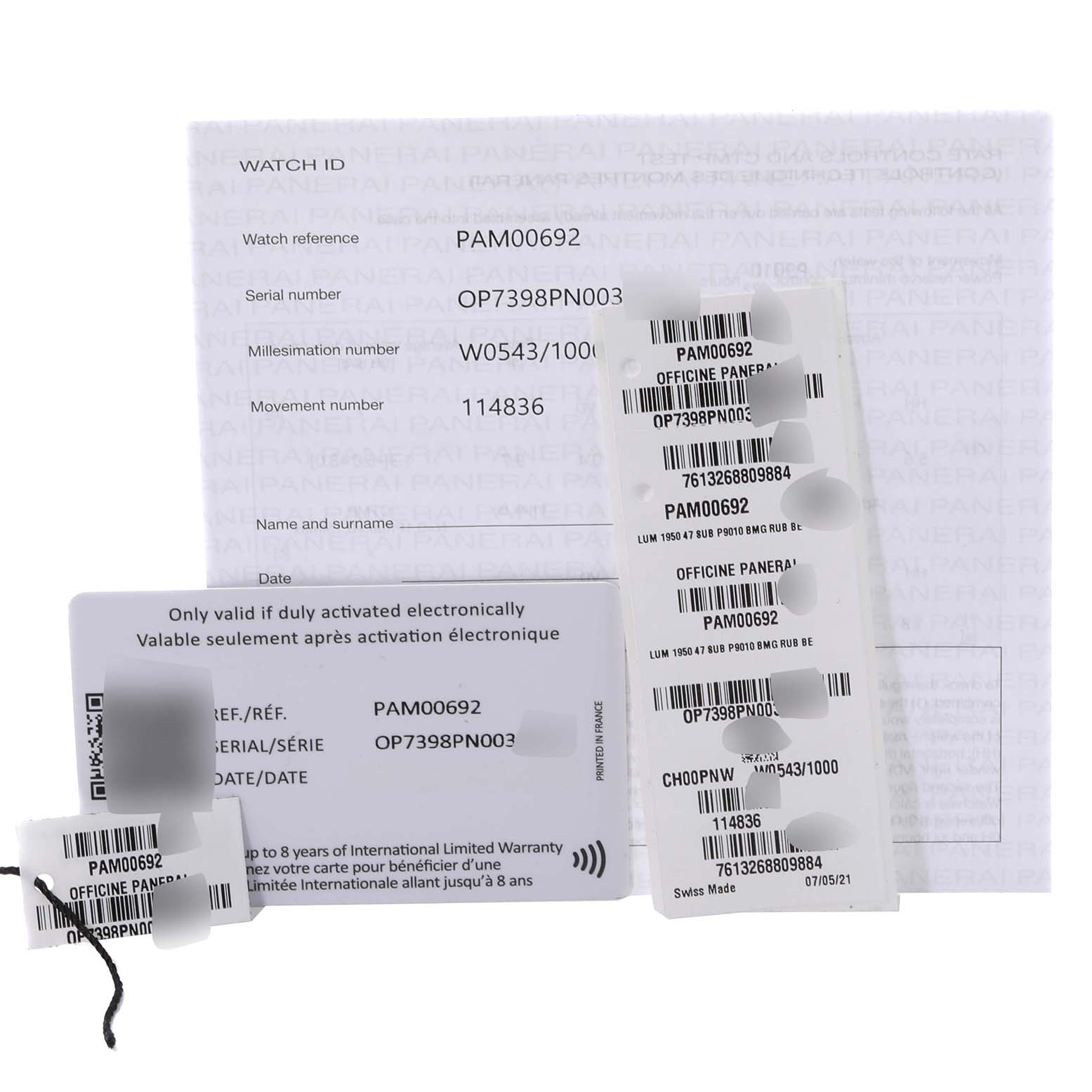 The image shows the warranty card, tags, and paperwork for the Panerai Submersible PAM00692 Men
s Titanium Blue Dial PAM00692 Men
s Titanium Blue Dial model PAM00692.