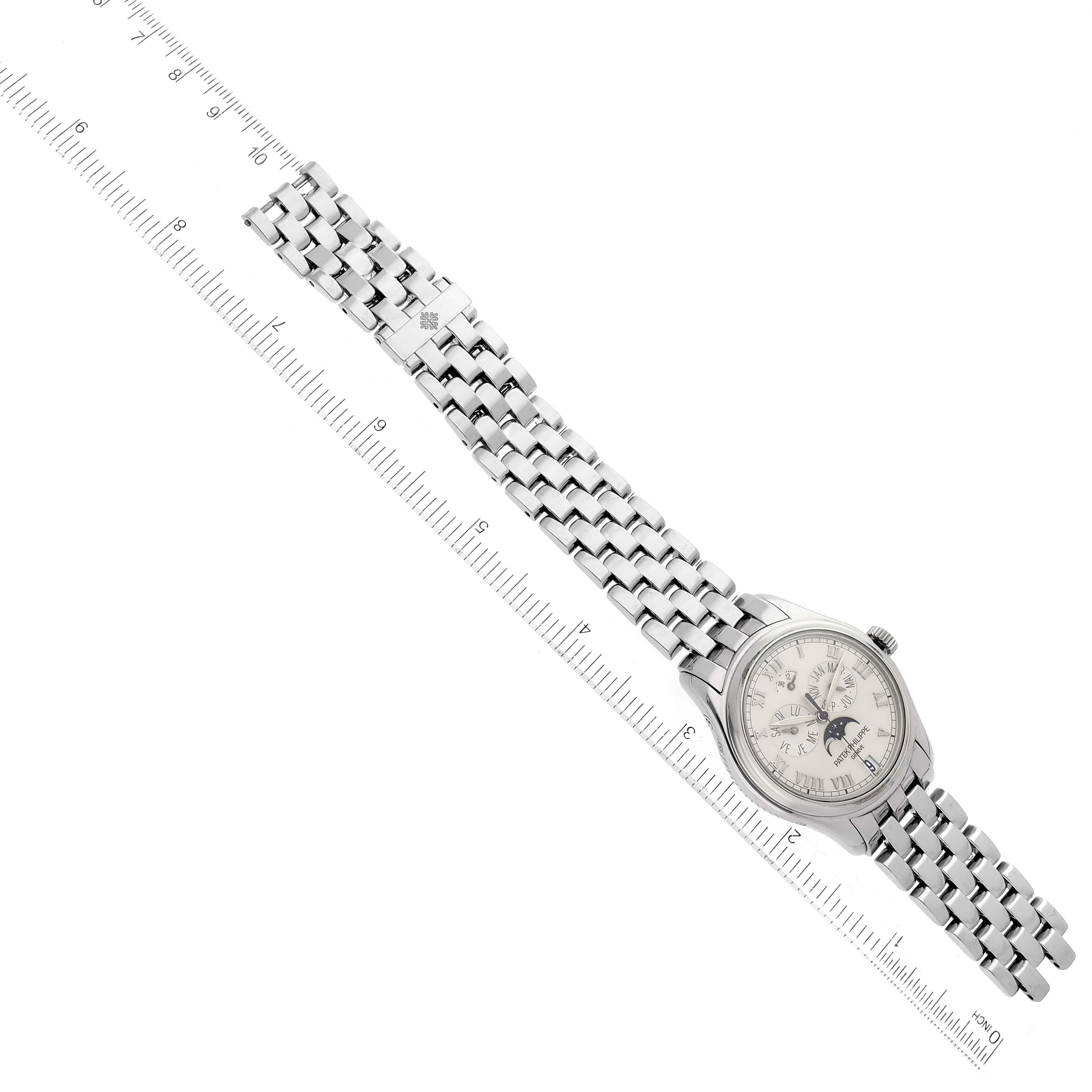 The image shows a Patek Philippe Complications 5036/1 Men
s White Gold Silver Dial 5036/1 Men
s White Gold Silver Dial model watch at an oblique angle, displaying its face, bracelet, and a ruler for scale.