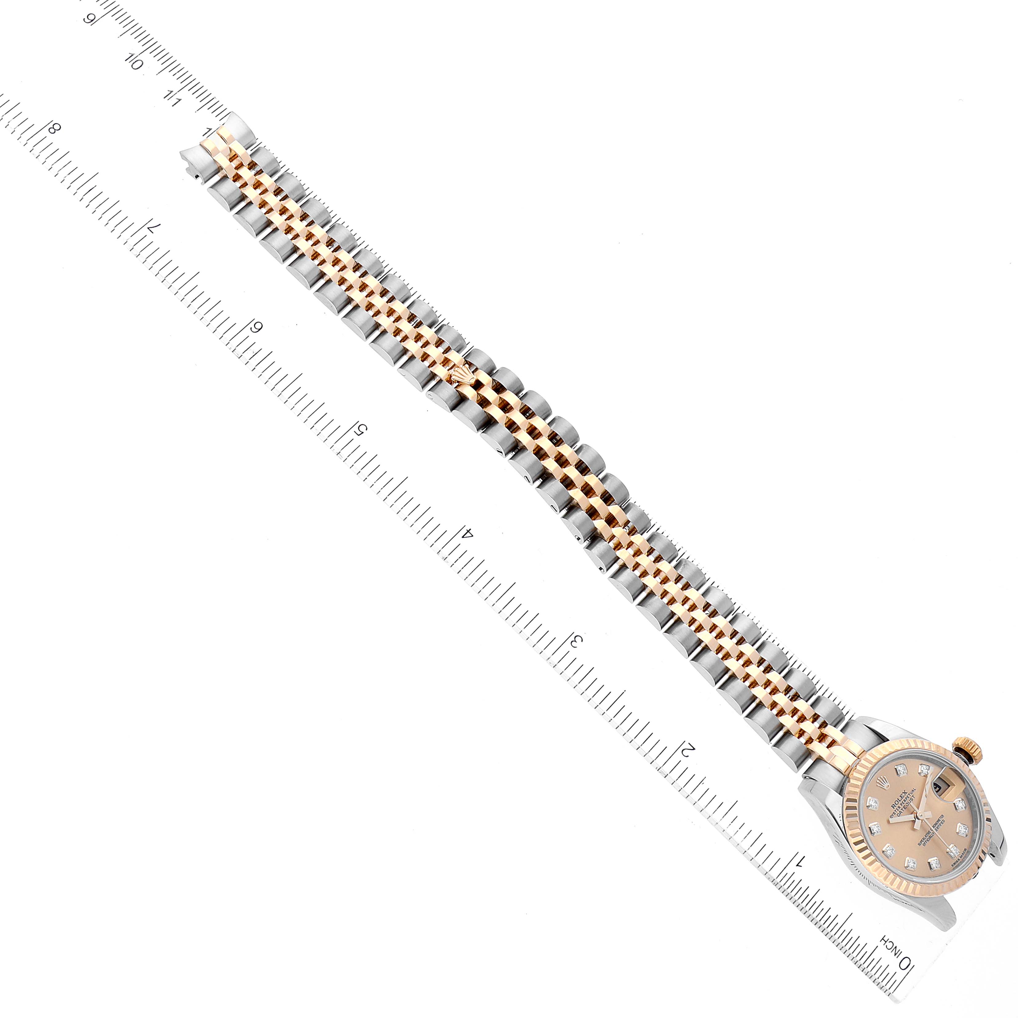 This image shows the side view of a Rolex Datejust 179173 Women's Steel and Gold (two tone) Champagne Dial 179173 Women's Steel and Gold (two tone) Champagne Dial watch, focusing on its two-tone bracelet and case, aligned with a ruler.
