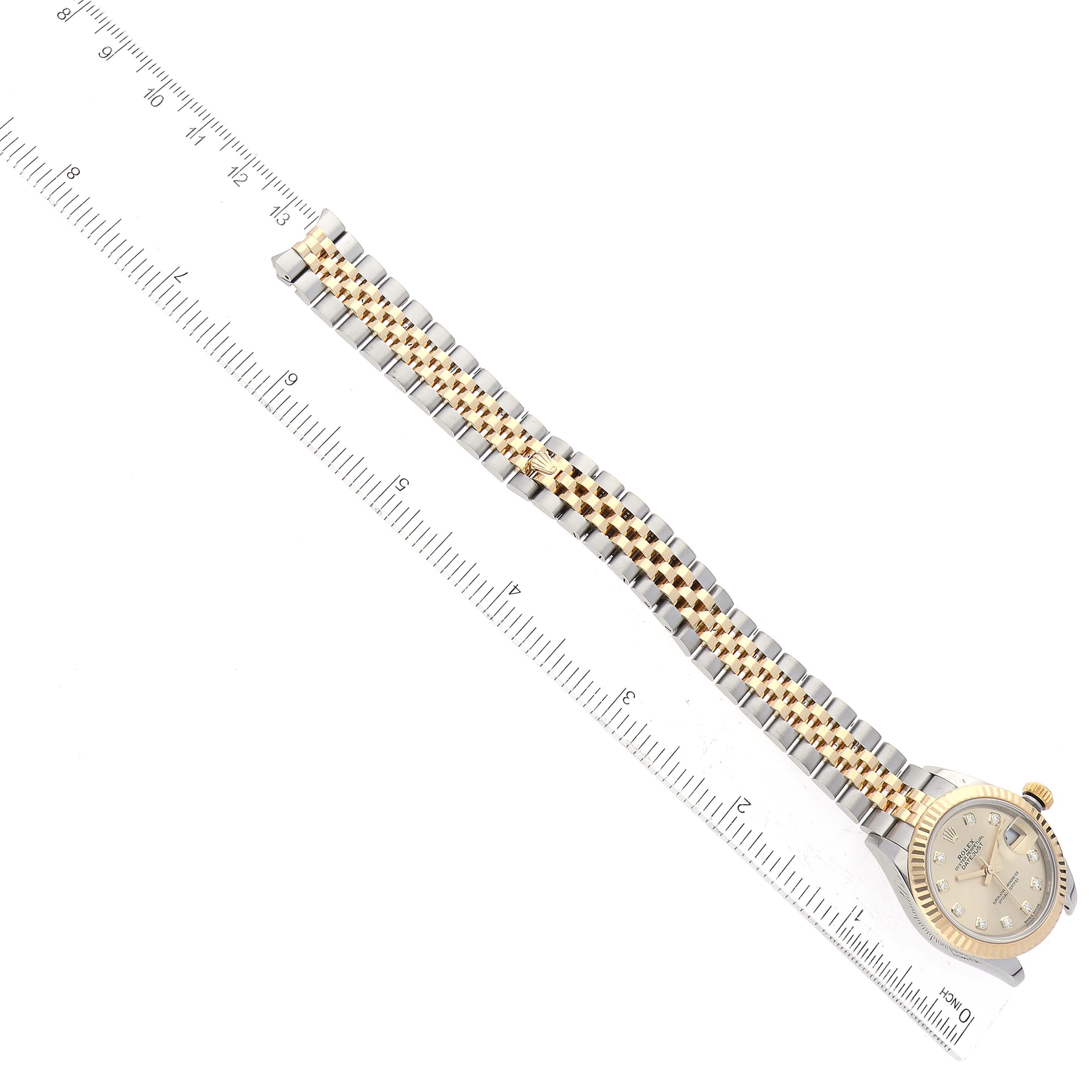 The image shows a Rolex Datejust 279173 Women's Steel and Gold (two tone) Champagne Dial 279173 Women's Steel and Gold (two tone) Champagne Dial watch from a top-down angle, displaying the face, bezel, crown, and metal bracelet alongside a ruler.