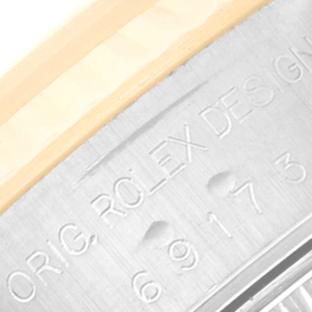 The image shows an extreme close-up of the engraved serial number and part of the bezel on a Rolex Datejust 69173 Women's Steel and Gold (two tone) Silver Dial 69173 Women's Steel and Gold (two tone) Silver Dial watch.