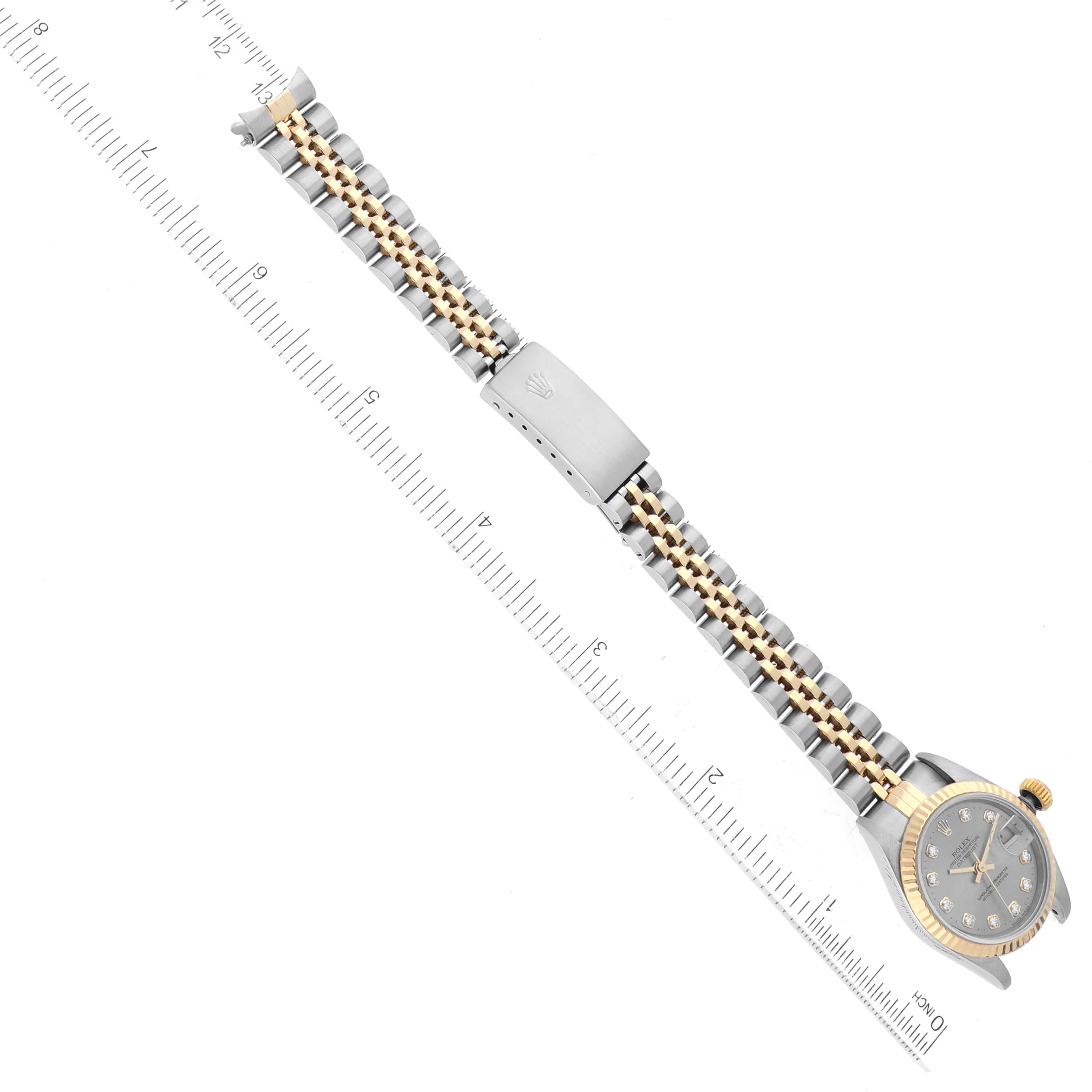 This image shows the Rolex Datejust 69173 Women's Steel and Gold (two tone) Silver Dial 69173 Women's Steel and Gold (two tone) Silver Dial watch laid flat from an overhead angle, alongside a measurement ruler for scale.