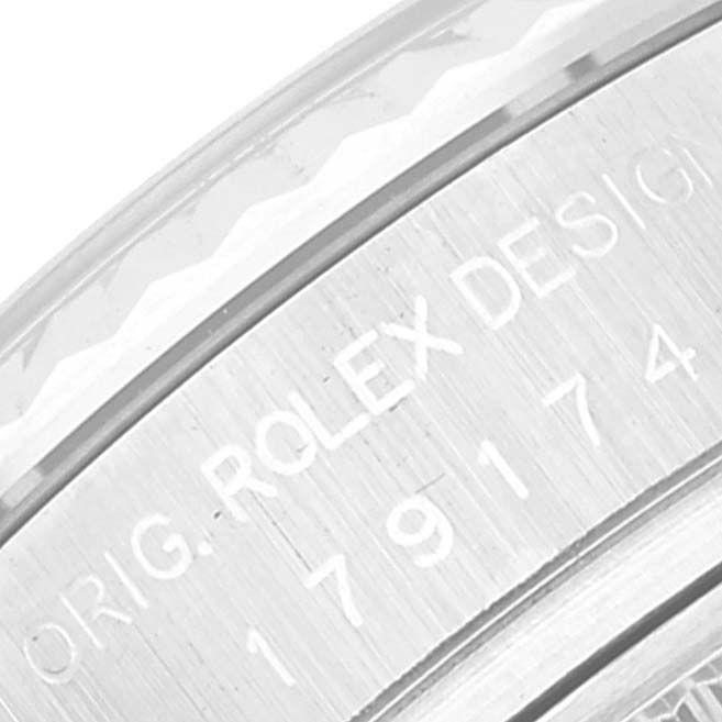 The image shows a close-up of the side of a Rolex Datejust 179174 Women's Stainless Steel Pink Dial 179174 Women's Stainless Steel Pink Dial watch, highlighting the engraved serial number and "ROLEX DESIGN" text.
