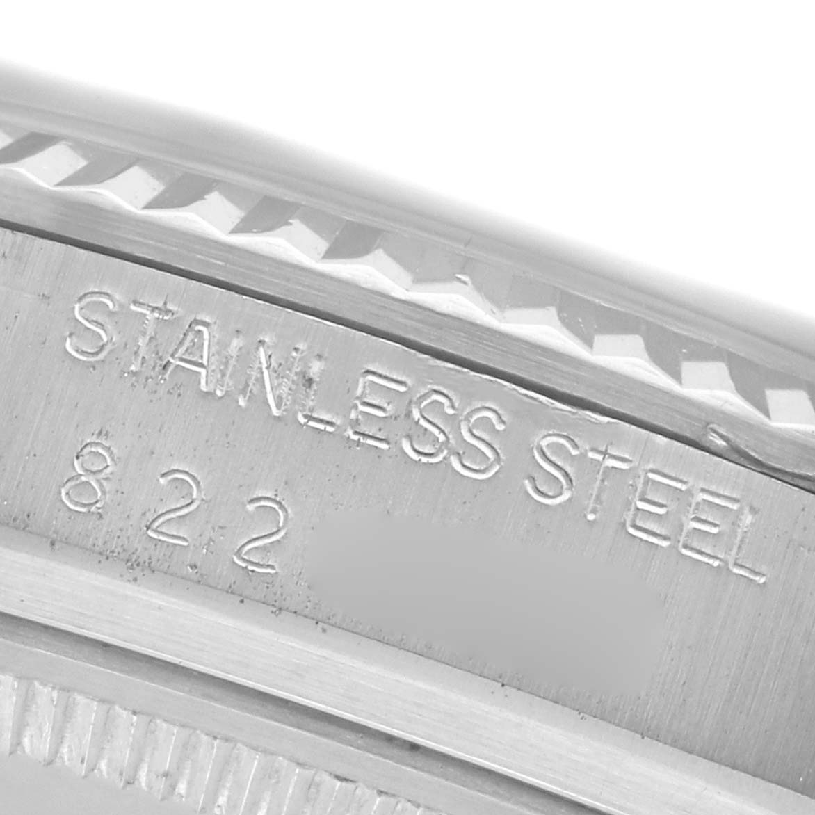The image shows an angled close-up of the side of a Rolex Datejust 16014 Men's Stainless Steel White Dial 16014 Men's Stainless Steel White Dial watch, highlighting the stainless steel engraving.