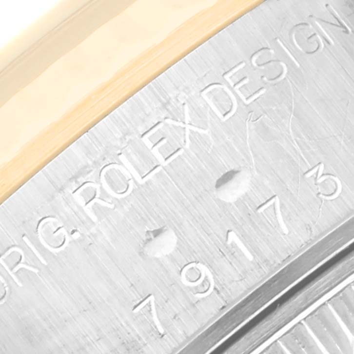 The image shows a close-up angle of the engraved inner bezel of a Rolex Datejust 79173 Women's Steel and Gold (two tone) Black Dial 79173 Women's Steel and Gold (two tone) Black Dial watch.